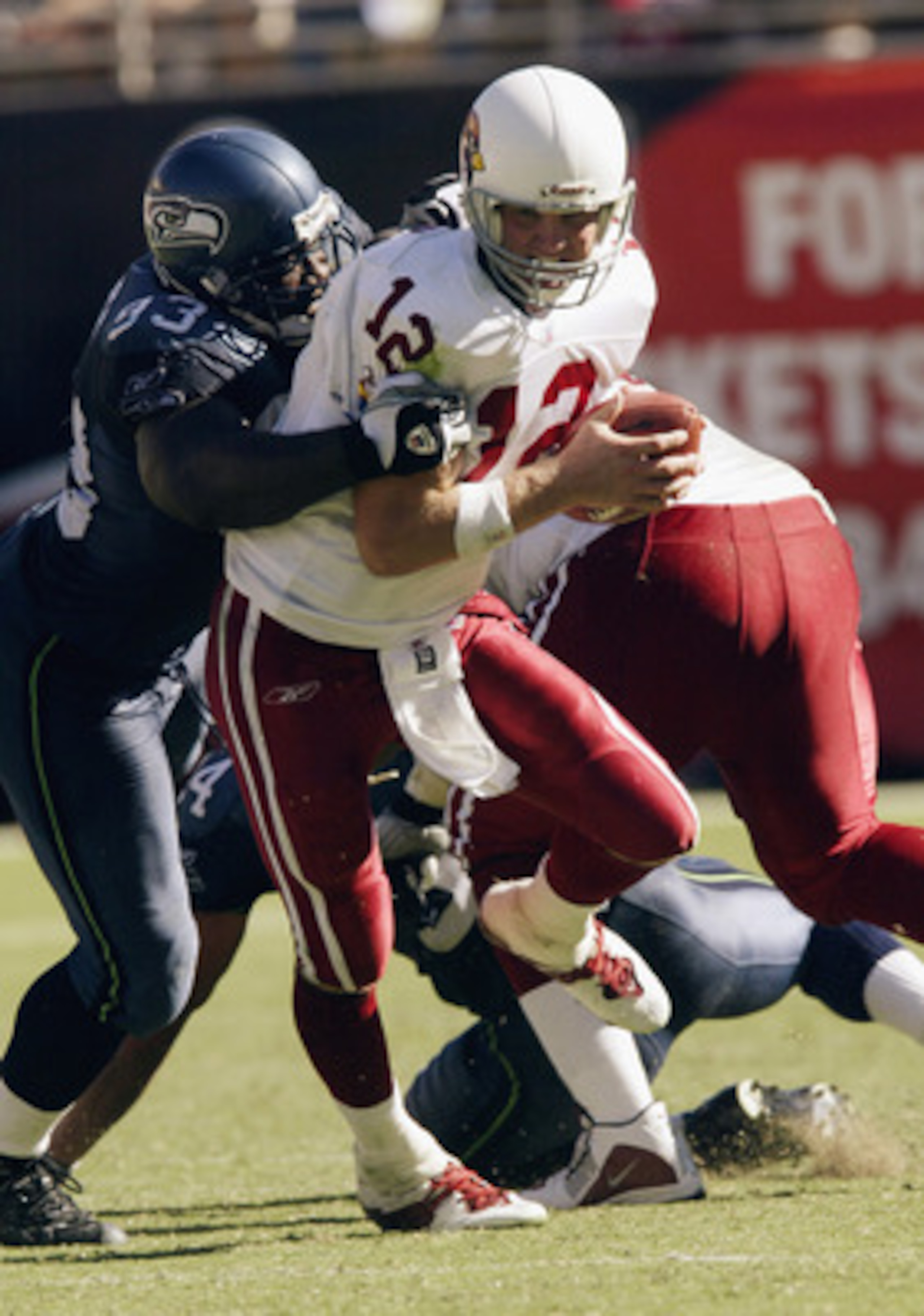 TEMPE, AZ - SEPTEMBER 14: Quarterback Josh McCown #12 of the Arizona Cardinals is brought down by defensive tackle John Randle #93 of the Seattle Seahawks on September 14, 2003 at Sun Devil Stadium in Tempe, Arizona. The Seahawks defeated the Cardinals TEMPE, AZ - SEPTEMBER 14: Quarterback Josh McCown #12 of the Arizona Cardinals is brought down by defensive tackle John Randle #93 of the Seattle Seahawks on September 14, 2003 at Sun Devil Stadium in Tempe, Arizona. The Seahawks defeated the Cardinals