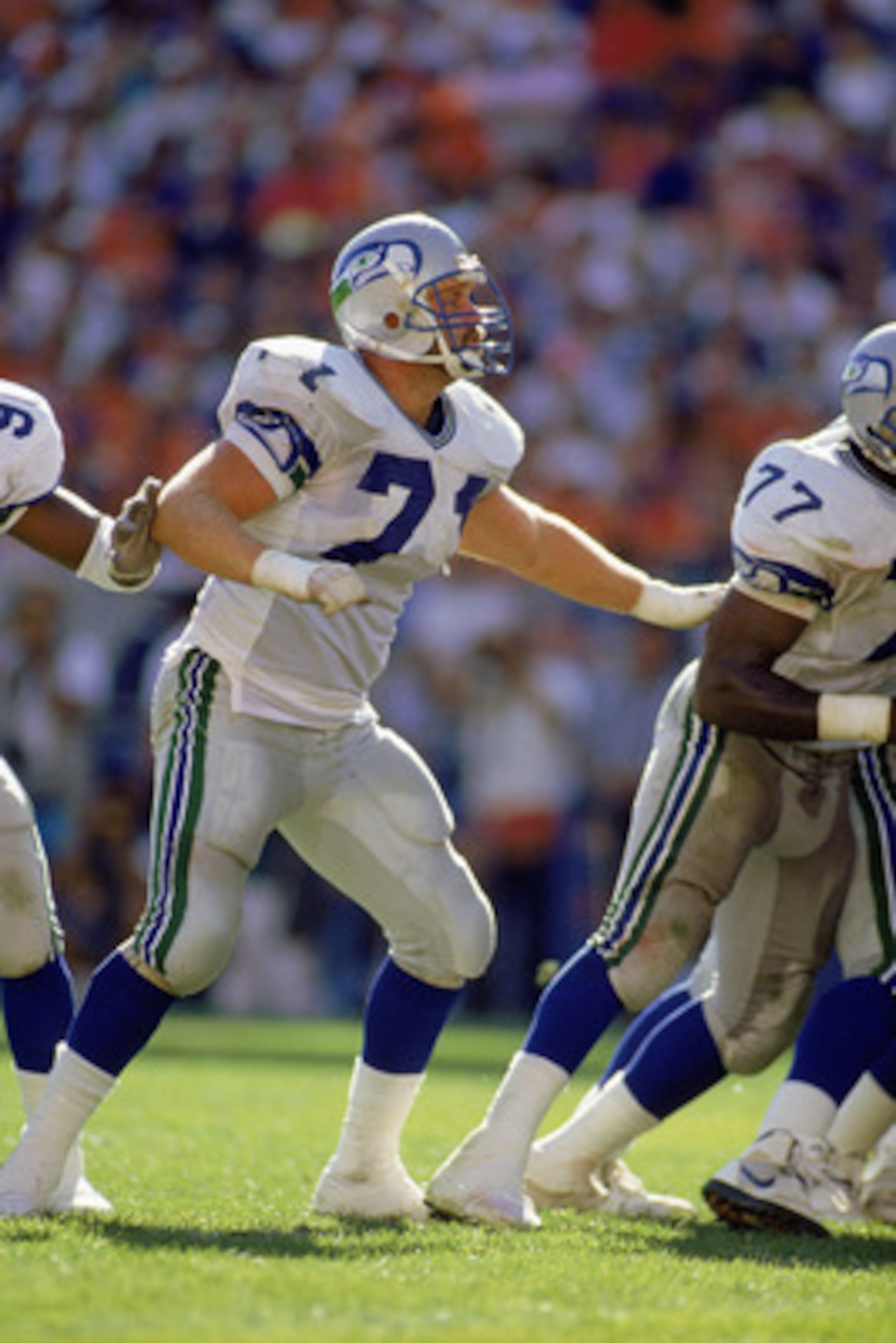 DENVER - SEPTEMBER 23:  Guard Bryan Millard #71 of the Seattle Seahawks moves down the line to make a block against the Denver Broncos on September 23, 1990 at Mile High Stadium in Denver, Colorado. The Broncos beat the Seahawks 34-31 in overtime. (Photo