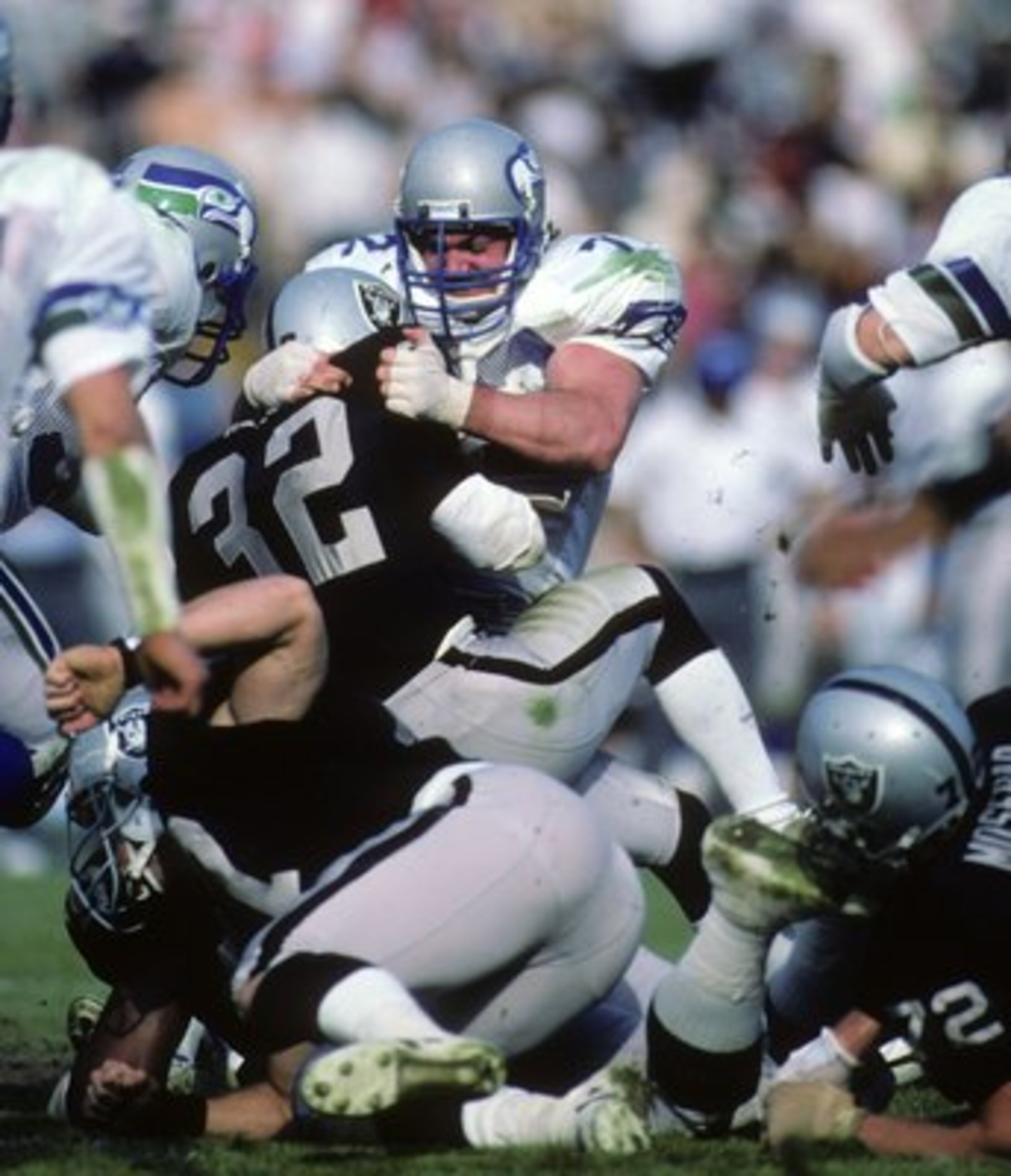 LOS ANGELES, CA - DECEMBER 15:  Defensive tackle Joe Nash #72 of the Seattle Seahawks tackles Los Angeles Raiders running back Marcus Allen #32 during the game at Los Angeles Memorial Coliseum on December 15, 1985 in Los Angeles, California.  The Raiders