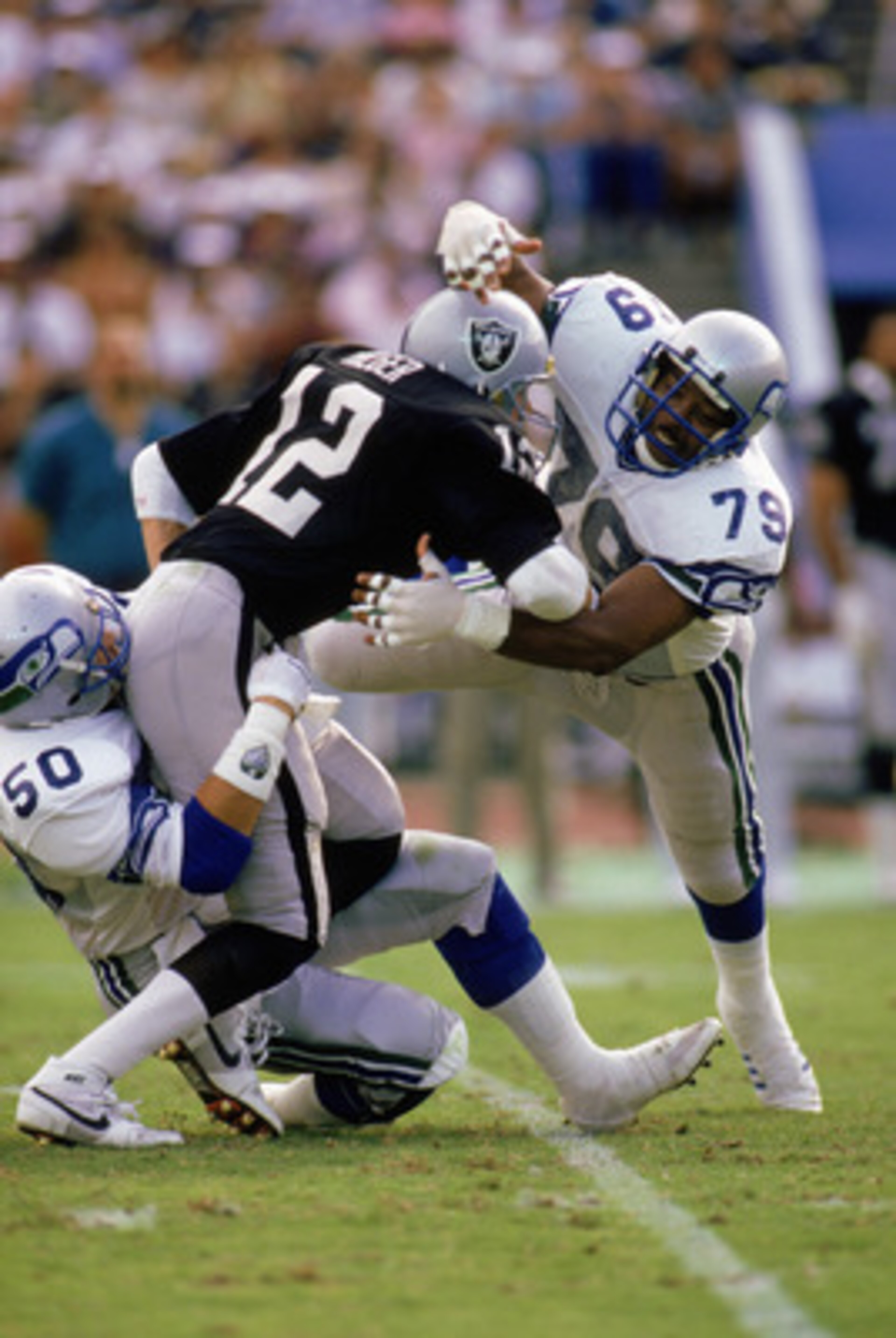 LOS ANGELES - DECEMBER 18:  Defensive end Jacob Green #79 of the Seattle Seahawks tackles a Los Angeles Raiders player on December 18, 1988 in the Los Angeles Coliseum in Los Angeles, California.  The Seahawks won 43-37. (Photo by Rick Stewart/Getty Image