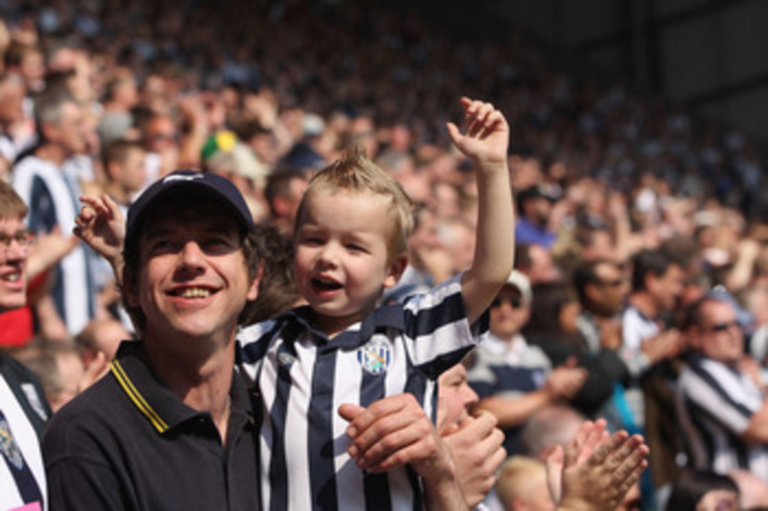 WEST BROMWICH, ENGLAND - APRIL 30: A father and his son supporters of West Brom look on during the Barclays Premier League match between West Bromwich Albion and Aston Villa at The Hawthorns on April 30, 2011 in West Bromwich, England.  (Photo by Michael