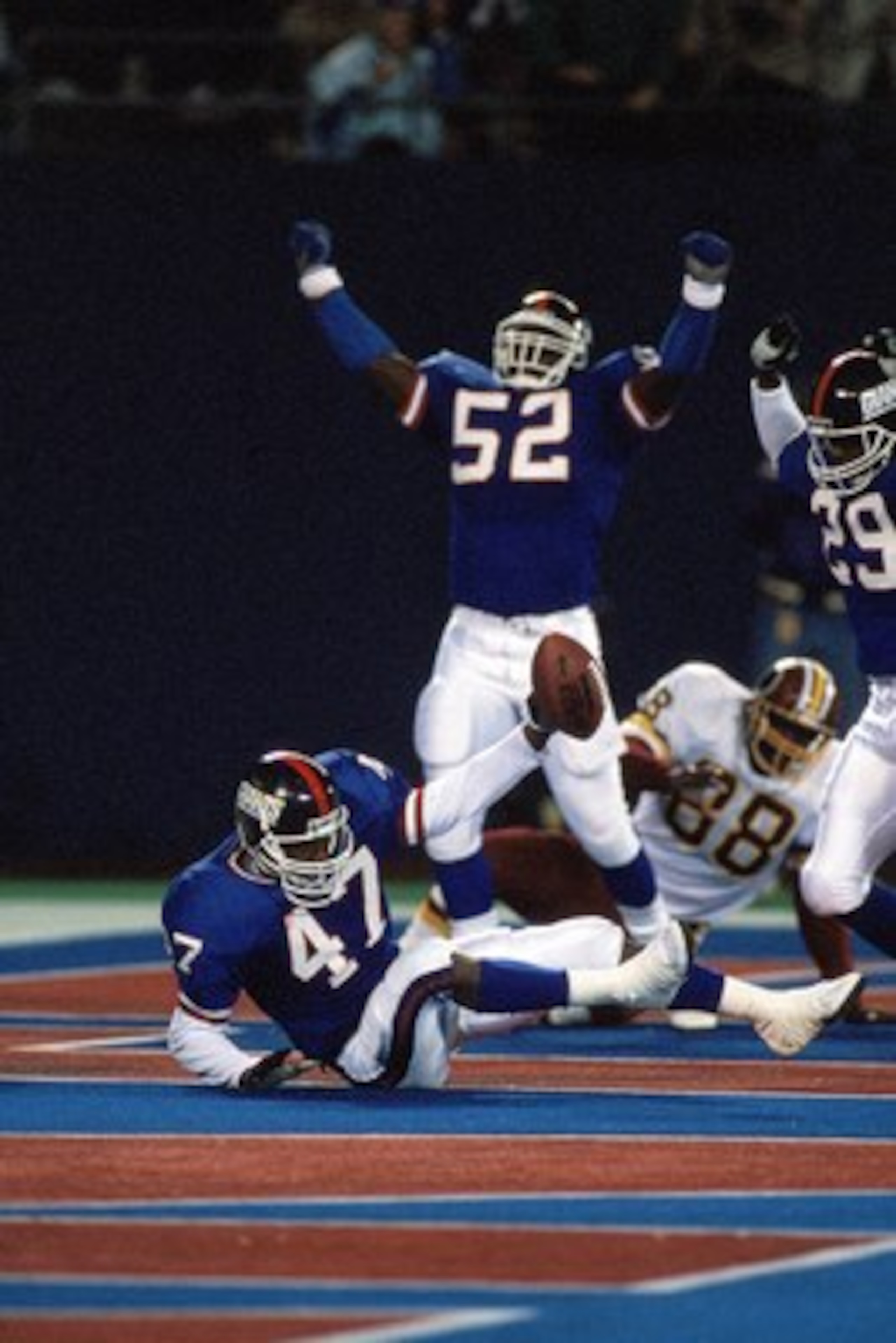 EAST RUTHERFORD, NJ - OCTOBER 28:  Linebacker Pepper Johnson #52 and safety Myron Guyton #29 of the New York Giants celebrate after the end zone interception by teammate Greg Jackson #47 during a game against the Washington Redskins at Giants Stadium Octo