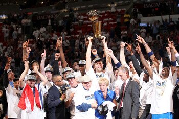 MIAMI, FL - JUNE 12:  Finals MVP Dirk Nowitzki #41 of the Dallas Mavericks celebrates with the Larry O'Brien Championship trophy along with Brendan Haywood #33, Caron Butler and team owner Mark Cuban after the Mavericks won 105-95 against the Miami Heat i