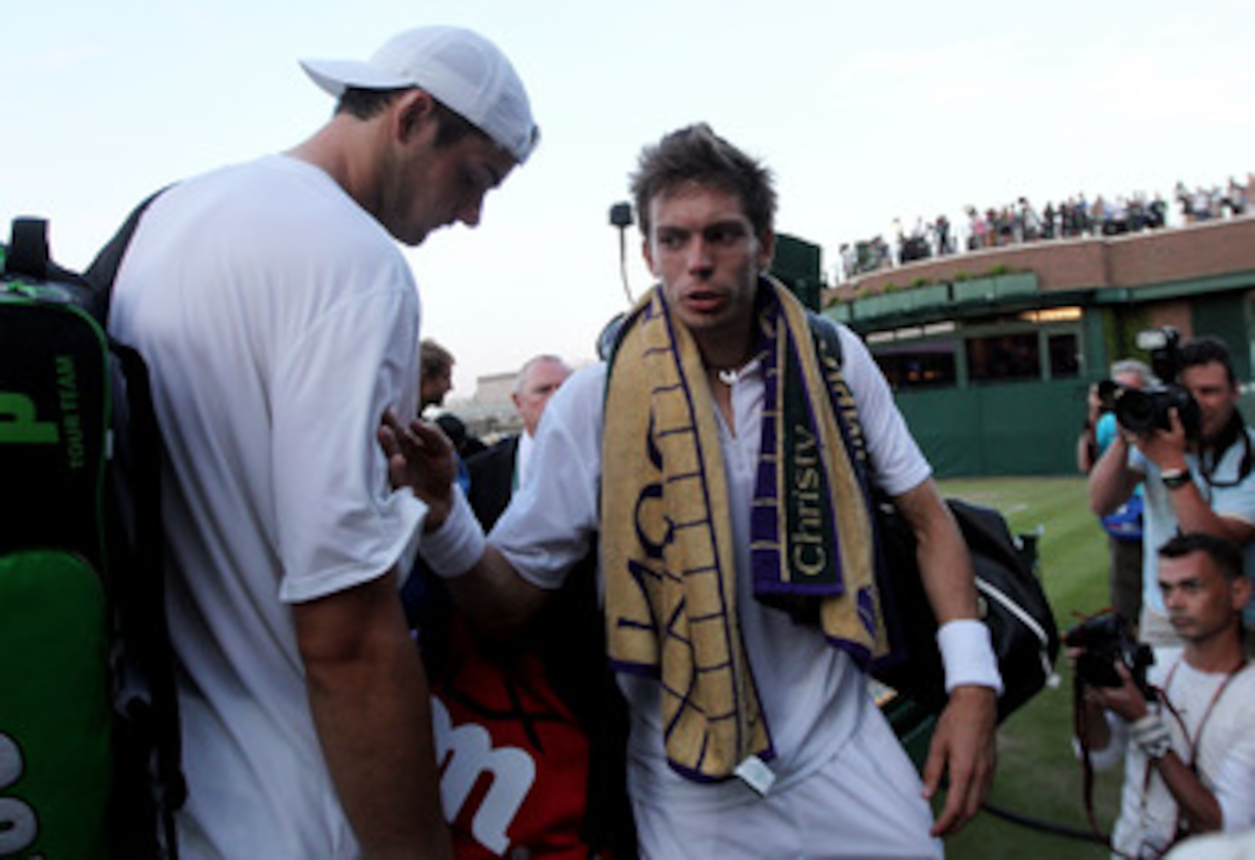 LONDON, ENGLAND - JUNE 23:  John Isner of USA (L) and Nicolas Mahut of France prepare to leave court 18 as light stops play at 59-59 in the last set on Day Three of the Wimbledon Lawn Tennis Championships at the All England Lawn Tennis and Croquet Club on