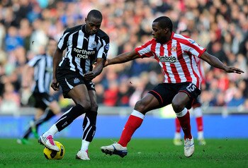 SUNDERLAND, ENGLAND - JANUARY 16:  Newcastle forward Shola Ameobi is challenged by Nedum Onuoha during the Barclays Premier League match between Sunderland and Newcastle United at Stadium of Light on January 16, 2011 in Sunderland, England.  (Photo by Stu