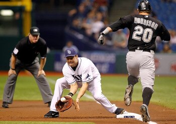 ST. PETERSBURG, FL - JUNE 18:  First baseman Casey Kotchman #11 of the Tampa Bay Rays takes the throw at first to get Logan Morrison #20 of the Florida Marlins for an out during the game at Tropicana Field on June 18, 2011 in St. Petersburg, Florida.  (Ph