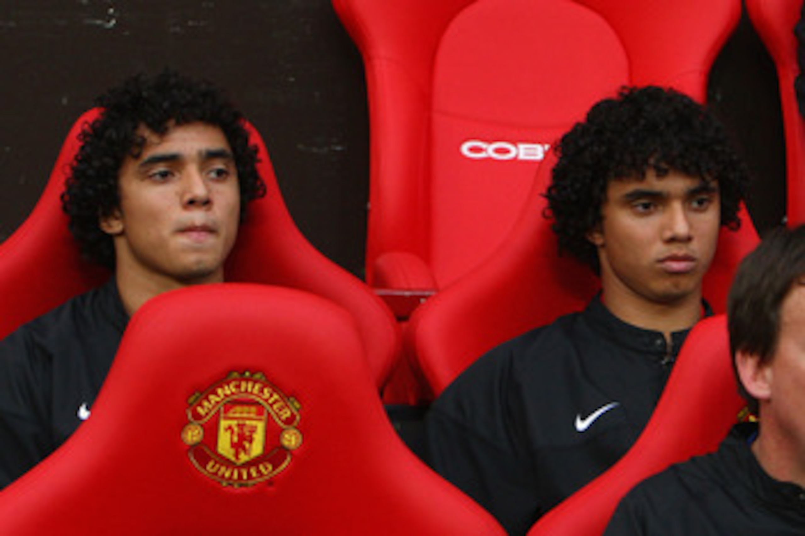 MANCHESTER, UNITED KINGDOM - AUGUST 06:  Rafael Da Silva (L) sits on the bench beside his twin brother and team mate Fabio Da Silva of Manchester United prior to the Pre Season Friendly match between Manchester United and Juventus at Old Trafford on Augus
