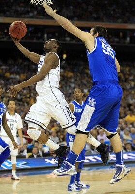 HOUSTON, TX - APRIL 02:  Kemba Walker #15 of the Connecticut Huskies goes to the hoop past Josh Harrellson #55 of the Kentucky Wildcats during the National Semifinal game of the 2011 NCAA Division I Men's Basketball Championship at Reliant Stadium on Apri