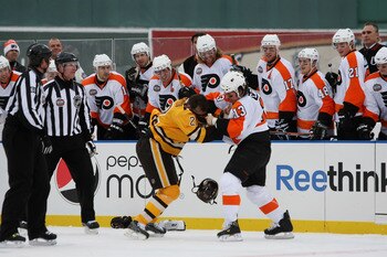 BOSTON - JANUARY 01:  Dan Carcillo #3 of the Philadelphia Flyers fights against Shawn Thornton #22 of the Boston Bruins as the refs and teammates look on during the first period of the 2010 Bridgestone Winter Classic at Fenway Park on January 1, 2010 in B