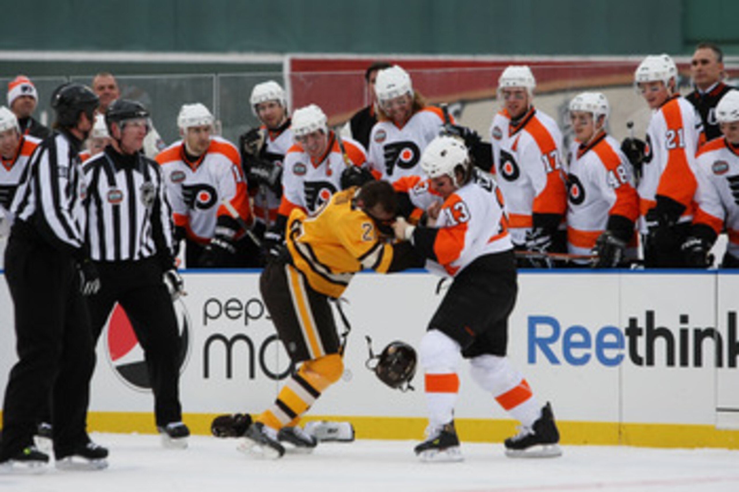 BOSTON - JANUARY 01:  Dan Carcillo #3 of the Philadelphia Flyers fights against Shawn Thornton #22 of the Boston Bruins as the refs and teammates look on during the first period of the 2010 Bridgestone Winter Classic at Fenway Park on January 1, 2010 in B