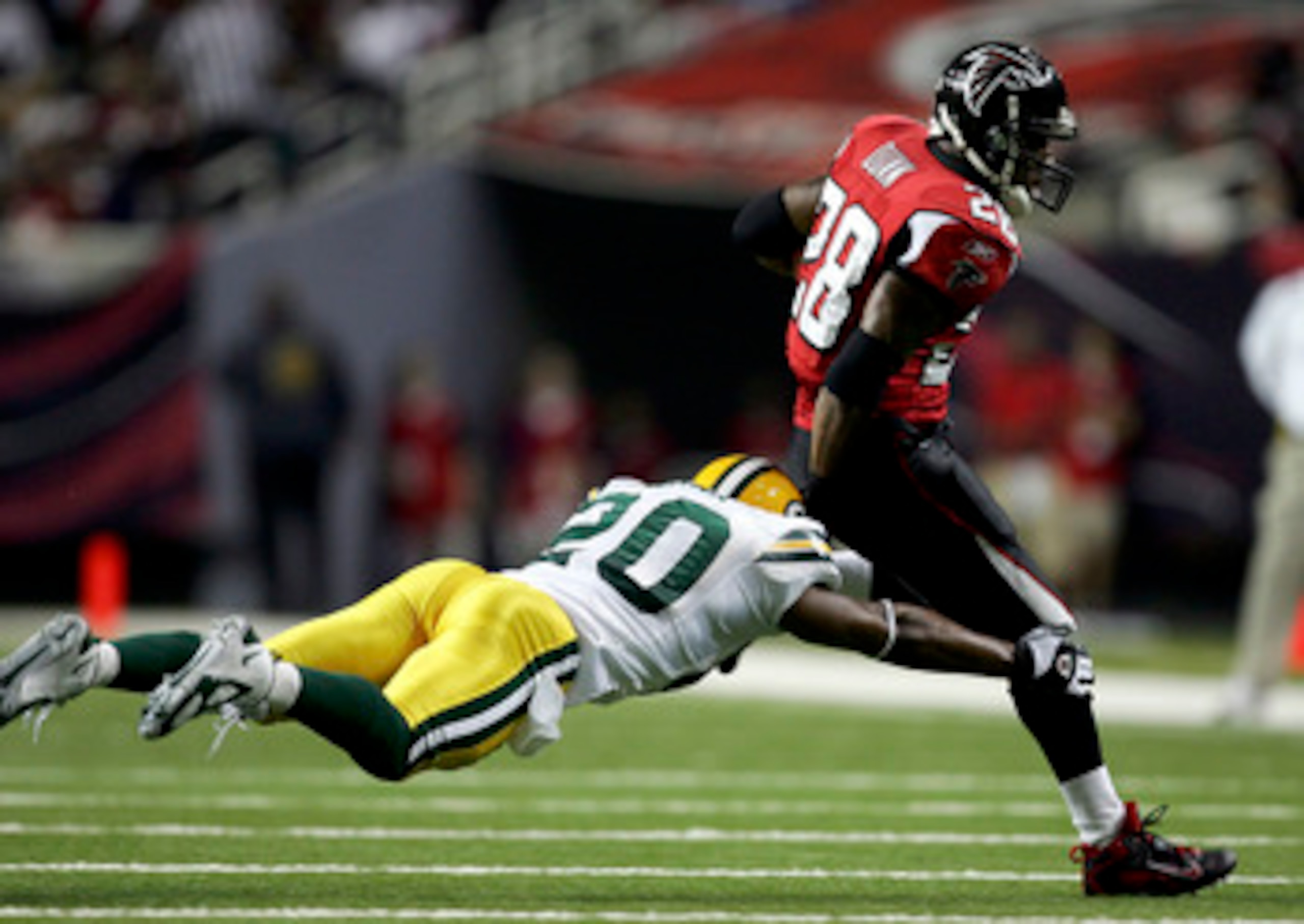 ATLANTA - NOVEMBER 13:  Mark Roman #20 of the Green Bay Packers chases down Warrick Dunn #28 of the Atlanta Falcons during their game on November 13, 2005 at the Georgia Dome in Atlanta, Georgia.  (Photo By Streeter Lecka)