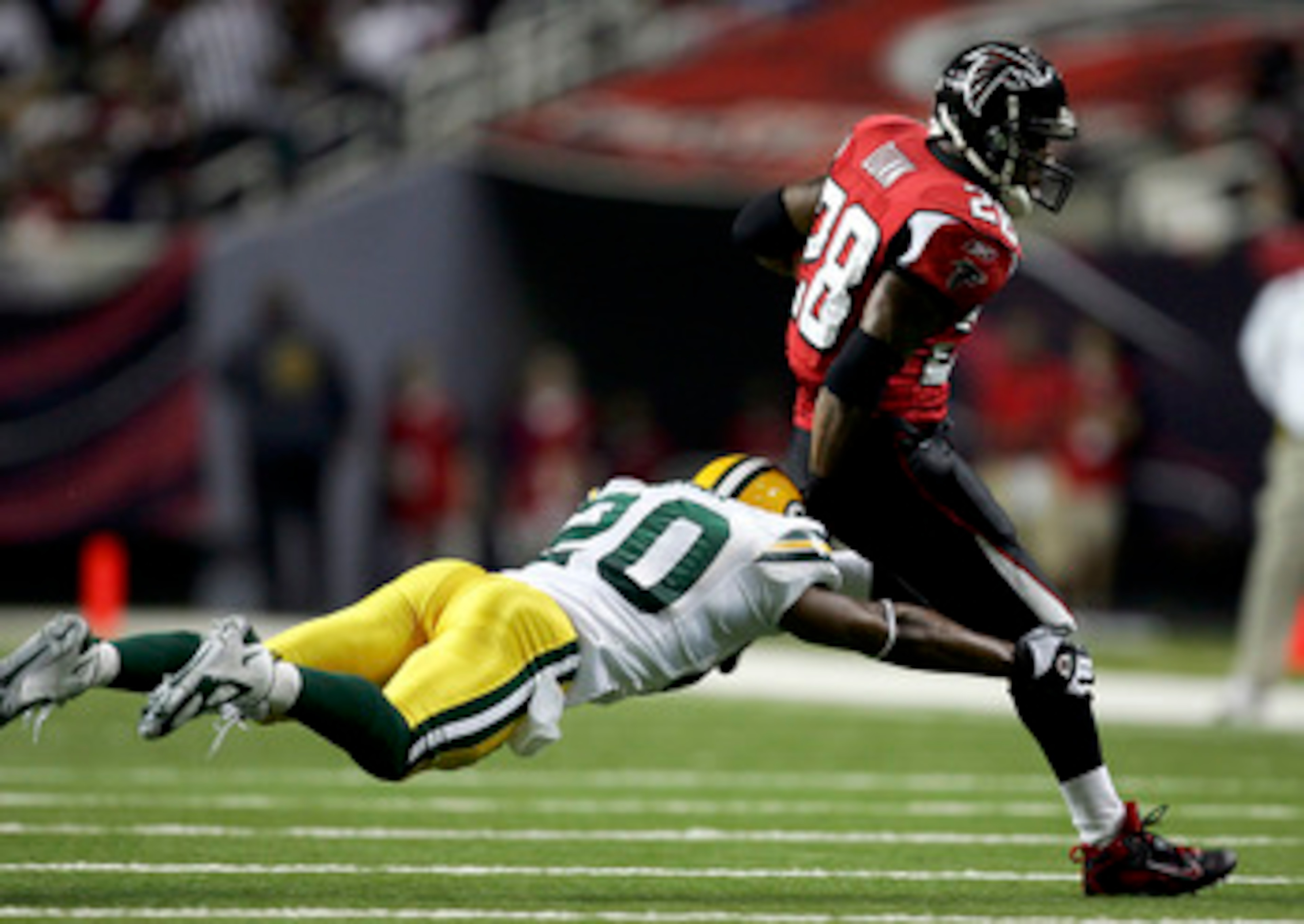ATLANTA - NOVEMBER 13:  Mark Roman #20 of the Green Bay Packers chases down Warrick Dunn #28 of the Atlanta Falcons during their game on November 13, 2005 at the Georgia Dome in Atlanta, Georgia.  (Photo By Streeter Lecka)