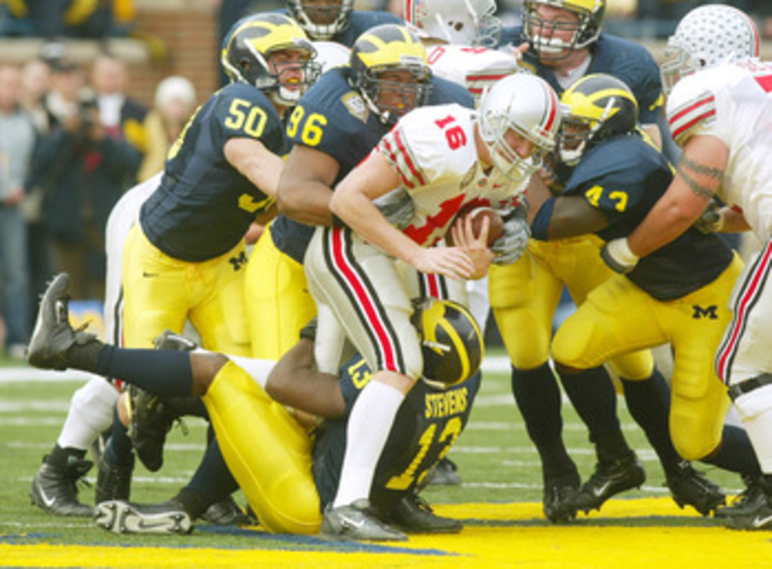 ANN ARBOR, MI - NOVEMBER 22:  Quarterback Craig Krenzel #16 of the Ohio State Buckeyes gets stopped as he attempts to run the ball through Jeremy Van Van Alstyne #50, Larry Harrison #96, Carl Diggs #43, and Larry Stevens #13  of the Michigan Wolvereins du