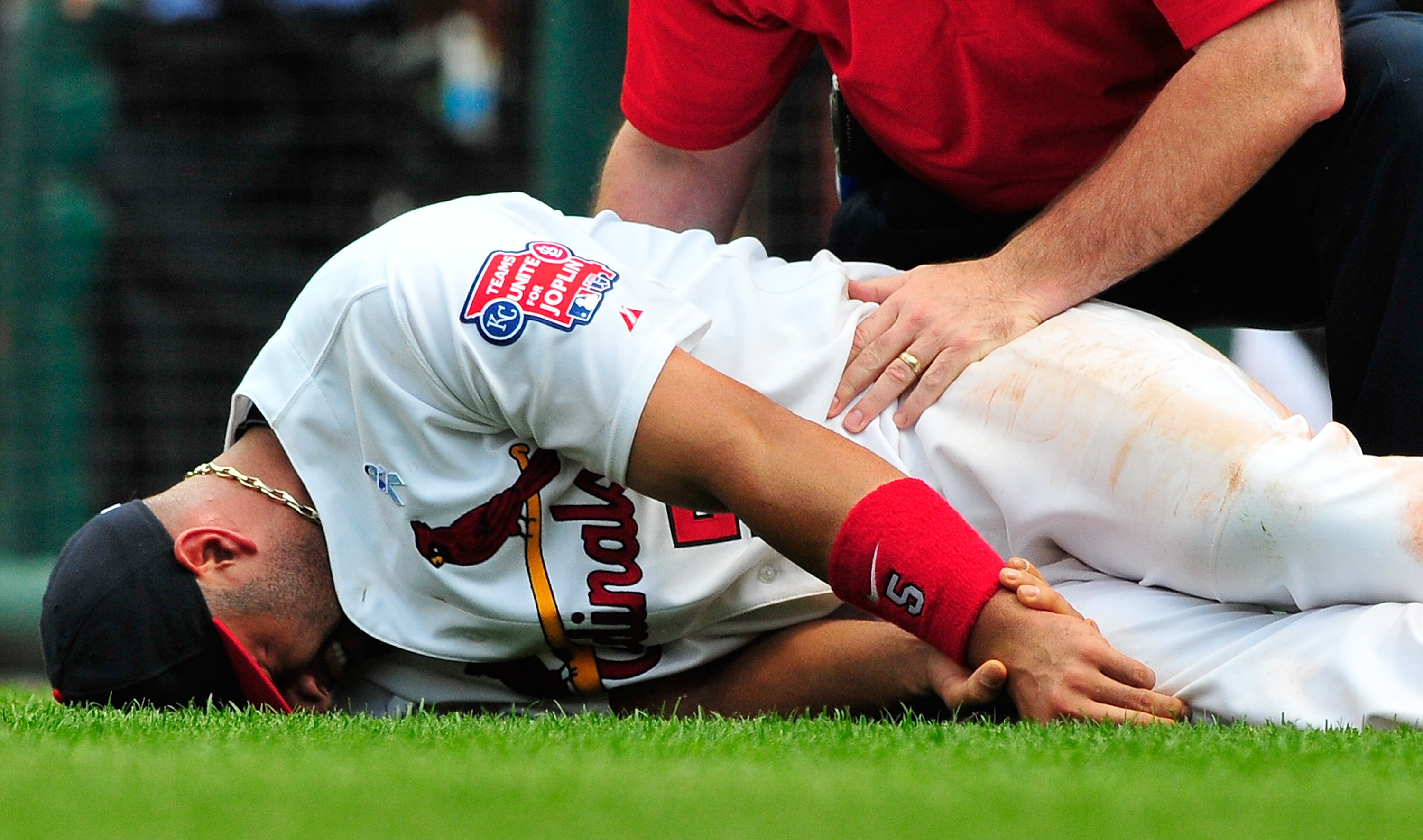 ST. LOUIS, MO - JUNE 19: Albert Pujols #5 of the St. Louis Cardinals holds his wrist after a collision with Wilson Betemit #24 of the Kansas City Royals at Busch Stadium on June 19, 2011 in St. Louis, Missouri.  (Photo by Jeff Curry/Getty Images)