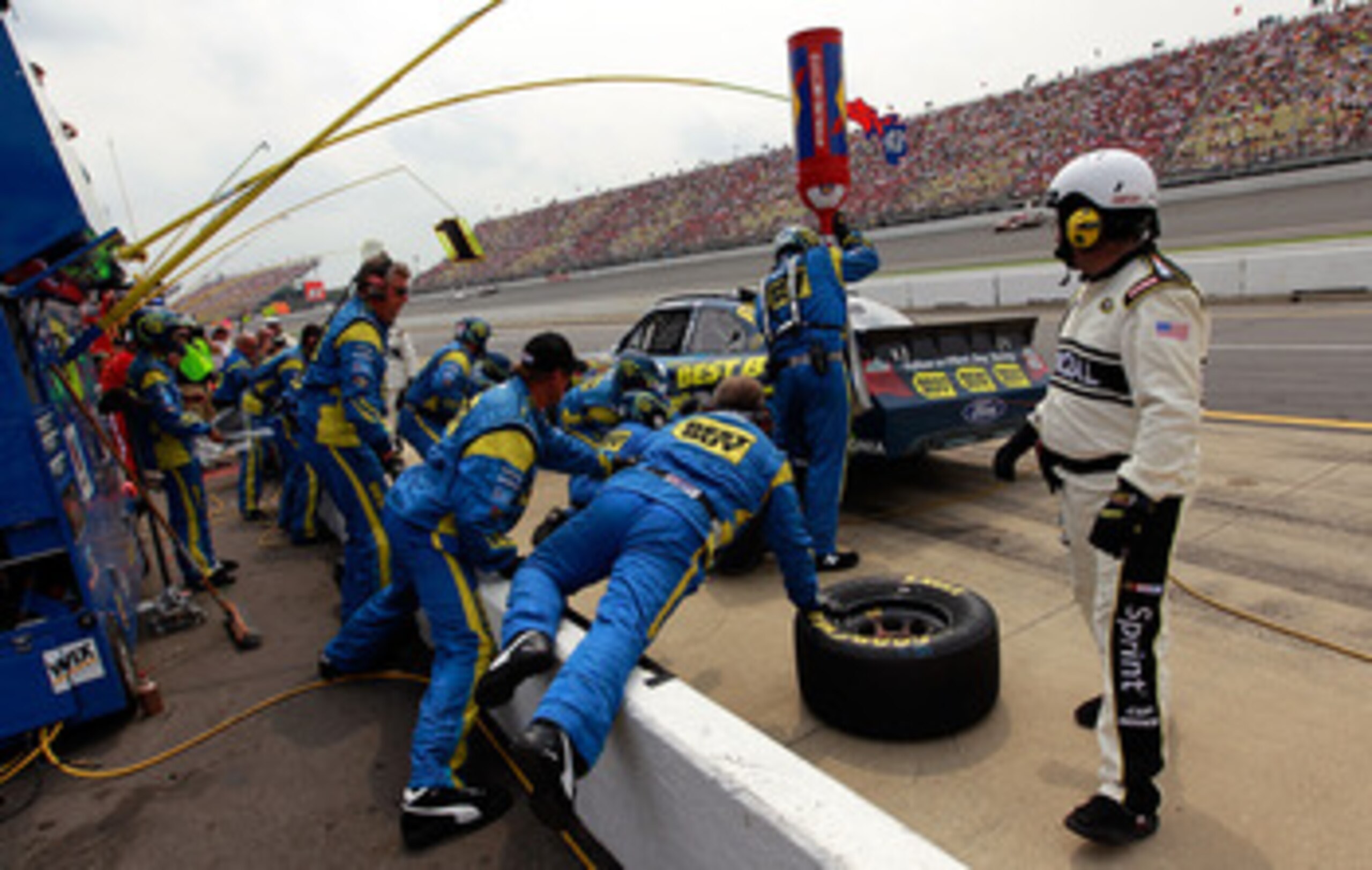 BROOKLYN, MI - JUNE 19:  A.J. Allmendinger, driver of the #43 Best Buy Ford, makes a pit stop during the NASCAR Sprint Cup Series Heluva Good! Sour Cream Dips 400 at Michigan International Speedway on June 19, 2011 in Brooklyn, Michigan.  (Photo by Tom Pe