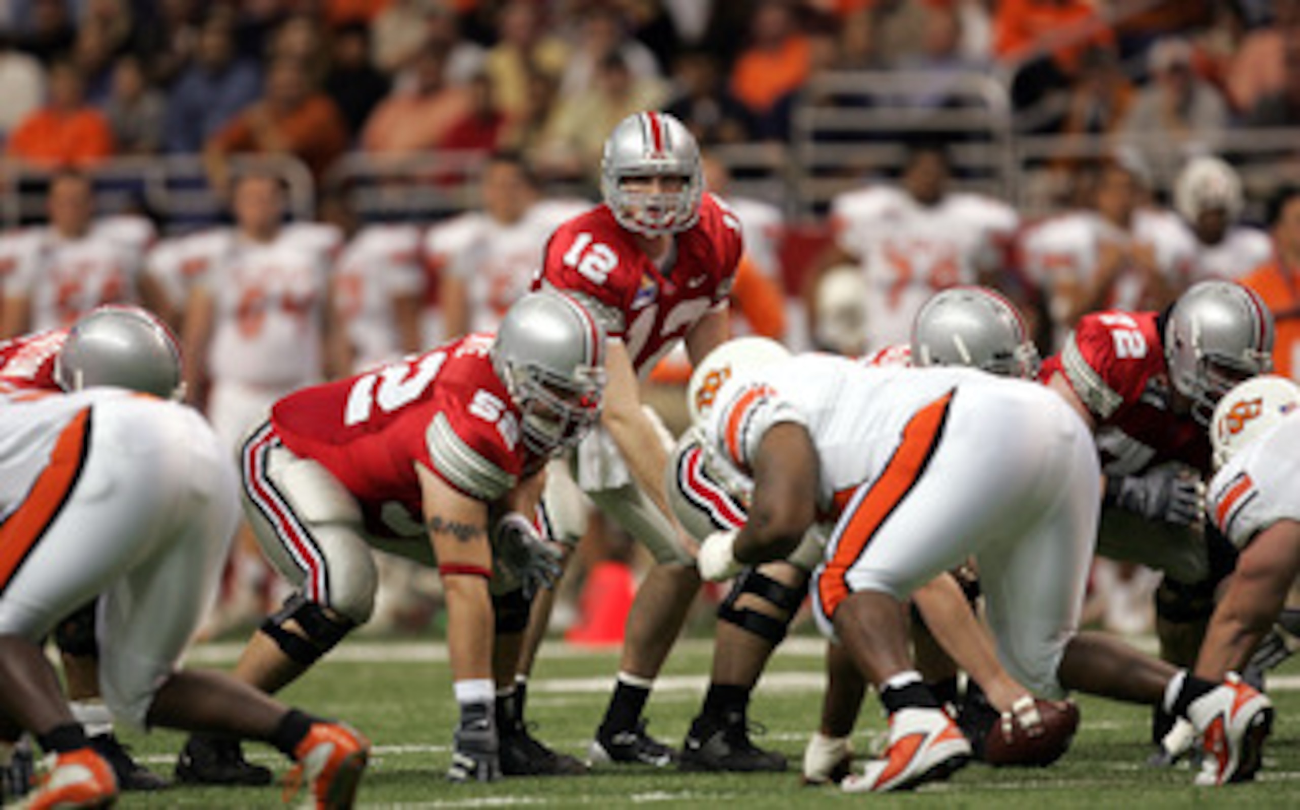 SAN ANTONIO, TX - DECEMBER 29:  Quarterback Justin Zwick #12 and guard Mike Kne #52 of the Ohio State Buckeyes line up against the Oklahoma State Cowboys during the MasterCard Alamo Bowl on December 29, 2004 at the Alamodome in San Antonio, Texas.  The Bu