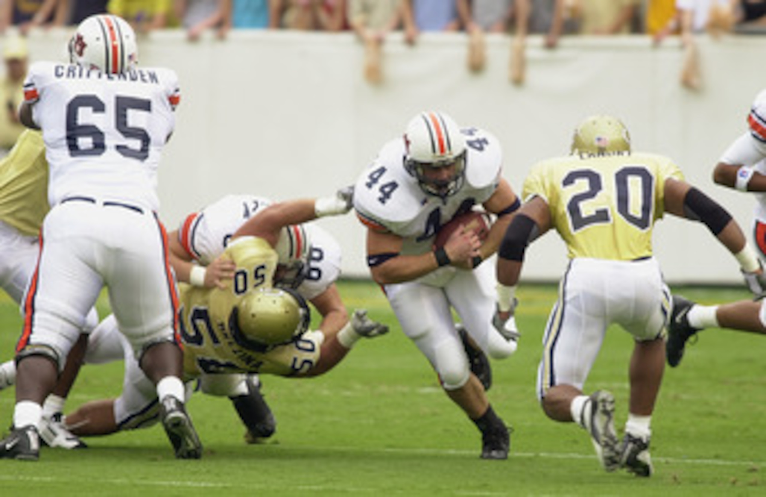 GEORGIA, ATLANTA - SEPTEMBER 6:  Fullback Jake Slaughter #44 of the Auburn Tigers runs through the hole toward safety Dawan Landry #20 of the Georgia Tech Yellow Jackets during the game on September 6, 2003 at Bobby Dodd Stadium/Grant Field in Atlanta, Ge