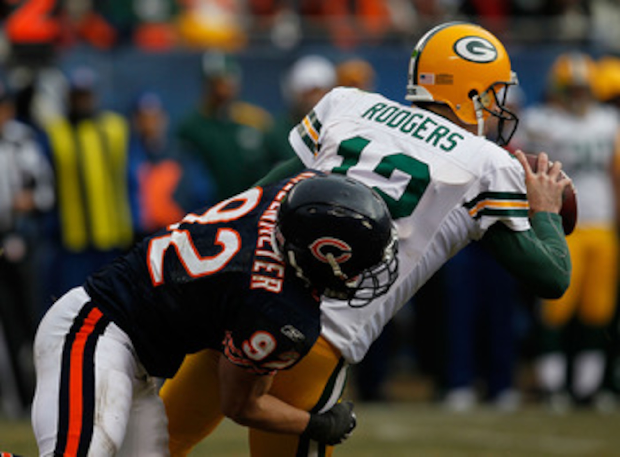 CHICAGO - DECEMBER 13: Aaron Rodgers #12 of the Green Bay Packers tosses the ball as he is brought down by Hunter Hillenmeyer #92 of the Chicago Bears at Soldier Field on December 13, 2009 in Chicago, Illinois. The Packers defeated the Bears 21-14. (Photo CHICAGO - DECEMBER 13: Aaron Rodgers #12 of the Green Bay Packers tosses the ball as he is brought down by Hunter Hillenmeyer #92 of the Chicago Bears at Soldier Field on December 13, 2009 in Chicago, Illinois. The Packers defeated the Bears 21-14. (Photo