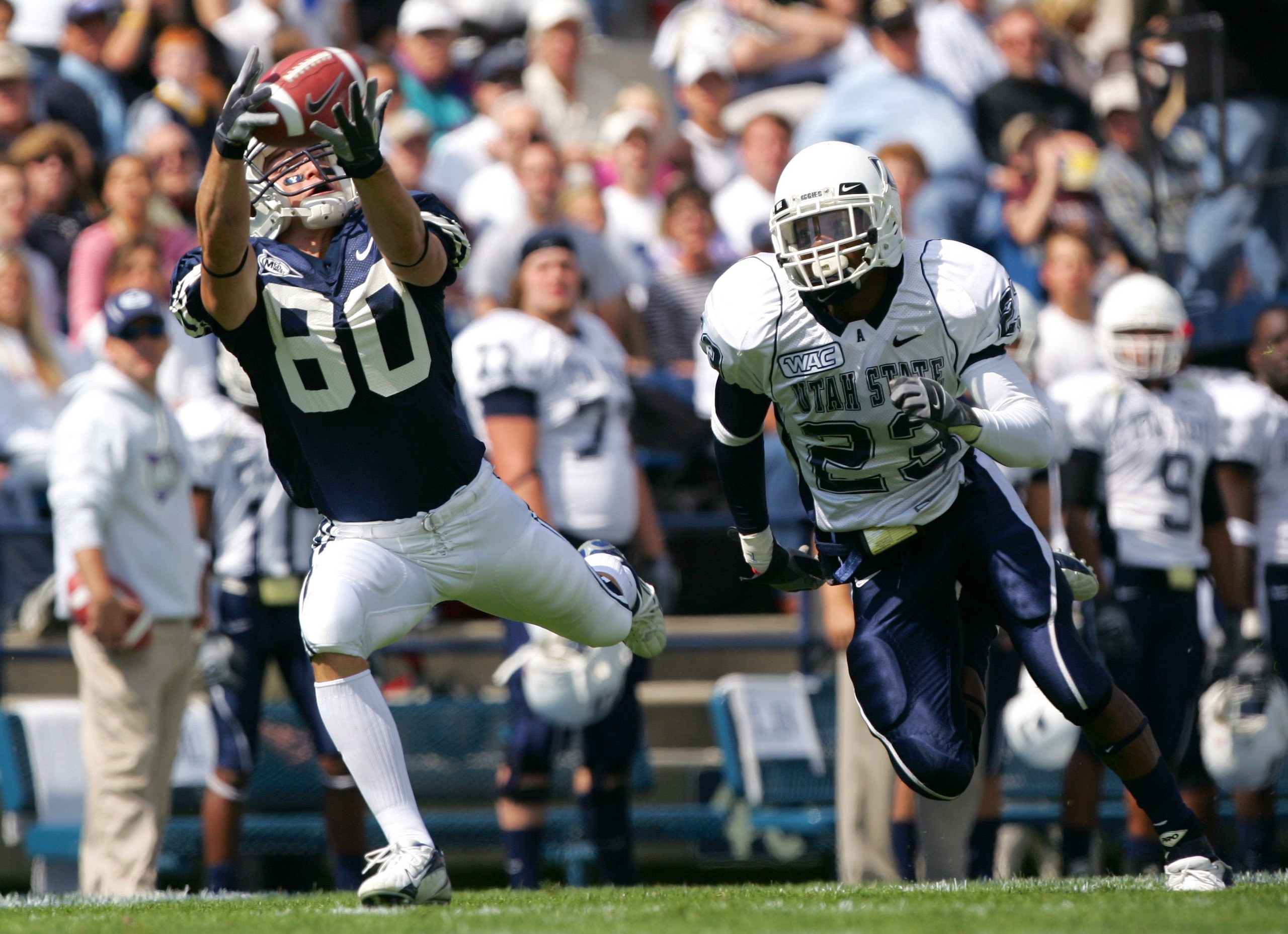 PROVO, UT - SEPTEMBER 23:  McKay Jacobson #80 of the Brigham Young Cougars catches the ball against Joshua Taylor #23 of the Utah State Aggies on September 23, 2006 at La Vell Edwards Stadium in Provo, Utah.  (Photo By Kent Horner/Getty Images)