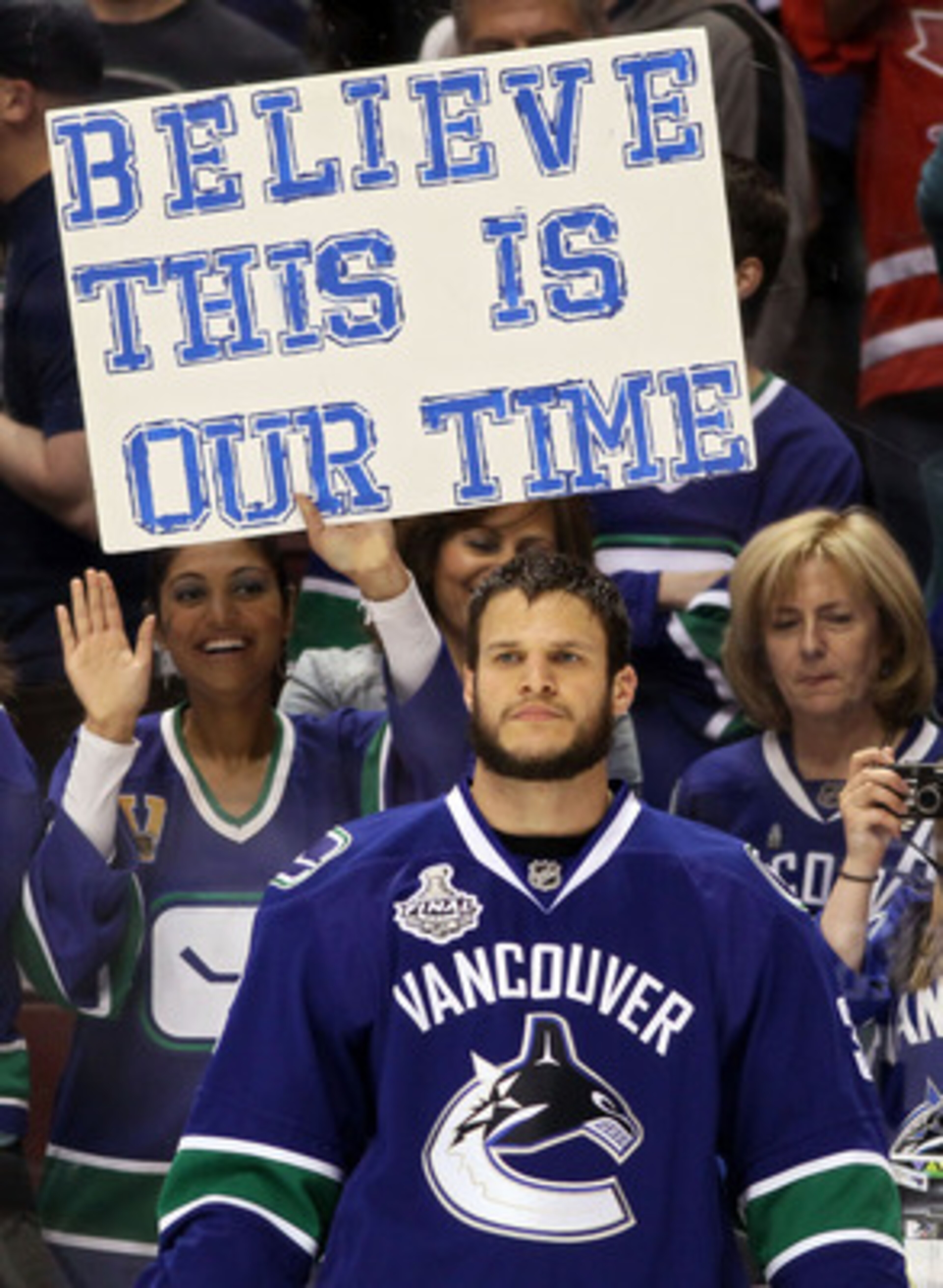 VANCOUVER, BC - JUNE 15:  Kevin Bieksa #3 of the Vancouver Canucks looks on as a Vancouver Canucks fan holds a sign that reads, 'BELIEVE THIS IS OUR TIME' prior to Game Seven against the Boston Bruins in the 2011 NHL Stanley Cup Final at Rogers Arena on J