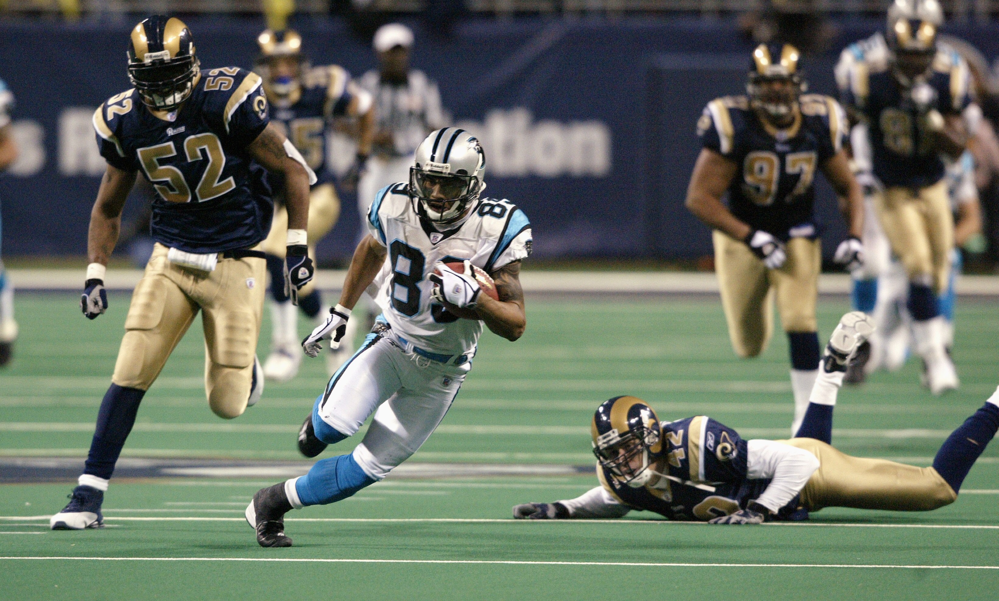 ST. LOUIS - JANUARY10:  Wide receiver Steve Smith #89 of the Carolina Panthers evades cornerback Jason Sehorn #42 and linebacker Tommy Polley #52 of the St. Louis Rams during the NFC Divisional Playoff game on January 10, 2004 at the Edward Jones Dome in