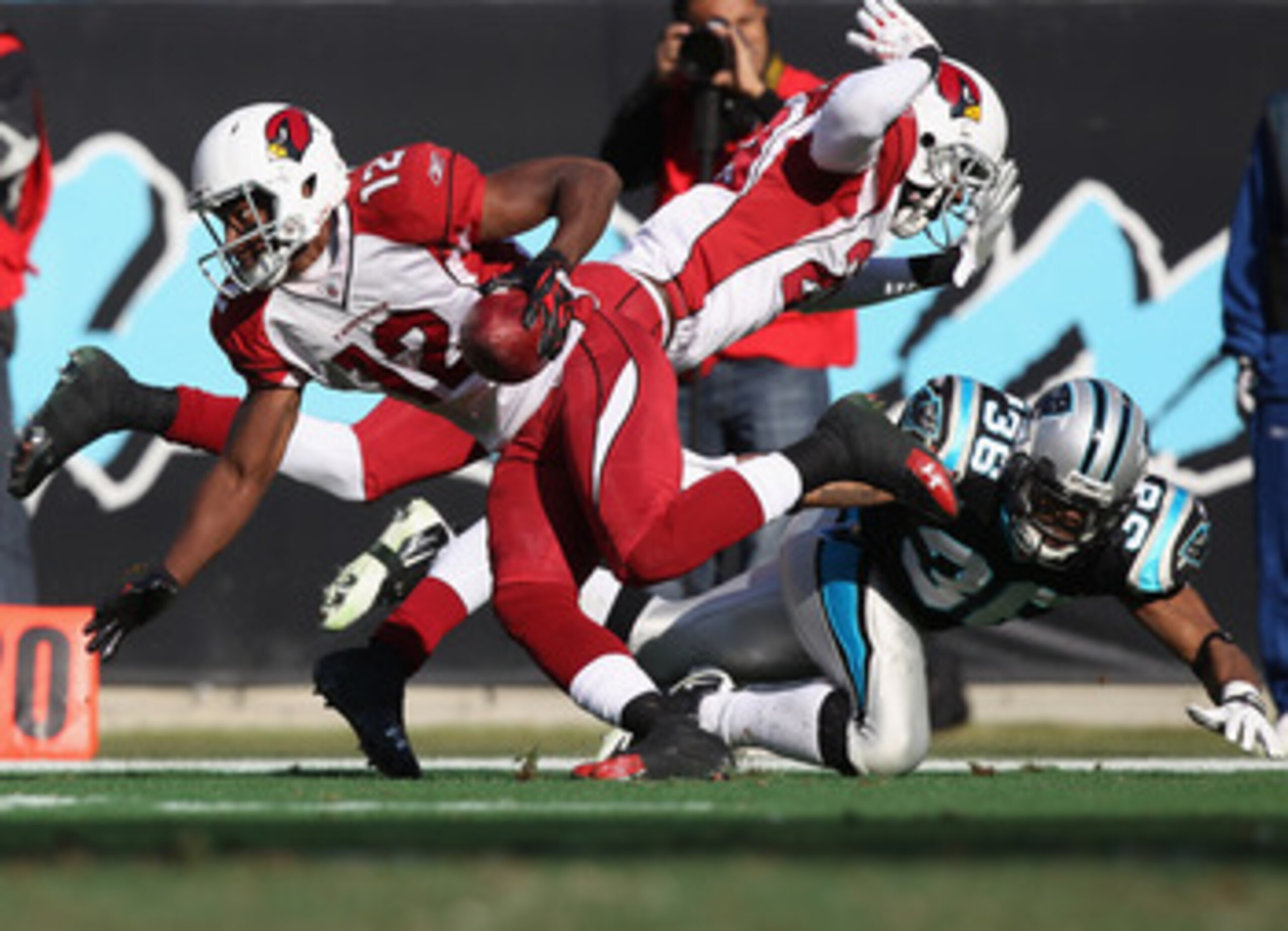 CHARLOTTE, NC - DECEMBER 19:  Dominique Rodgers-Cromartie #29 of the Arizona Cardinals hits Robert McClain #36 of the Carolina Panthers in the back as Andre Roberts #12 returns a punt during their game at Bank of America Stadium on December 19, 2010 in Ch