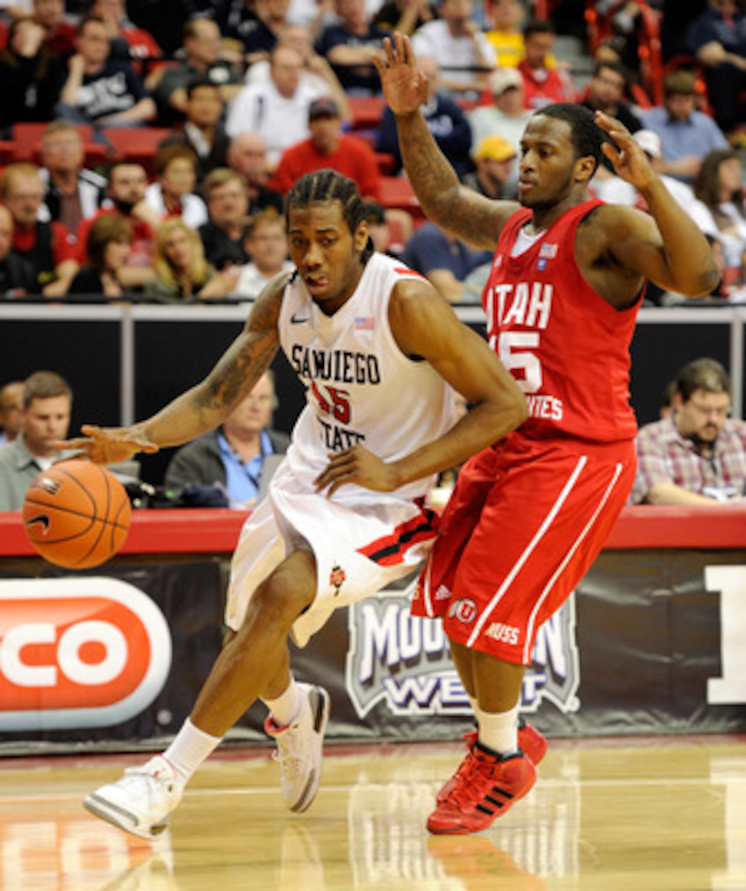 LAS VEGAS, NV - MARCH 10:  Kawhi Leonard #15 of the San Diego State Aztecs drives against Josh Watkins #15 of the Utah Utes during a quarterfinal game of the Conoco Mountain West Conference Basketball tournament at the Thomas & Mack Center March 10, 2011