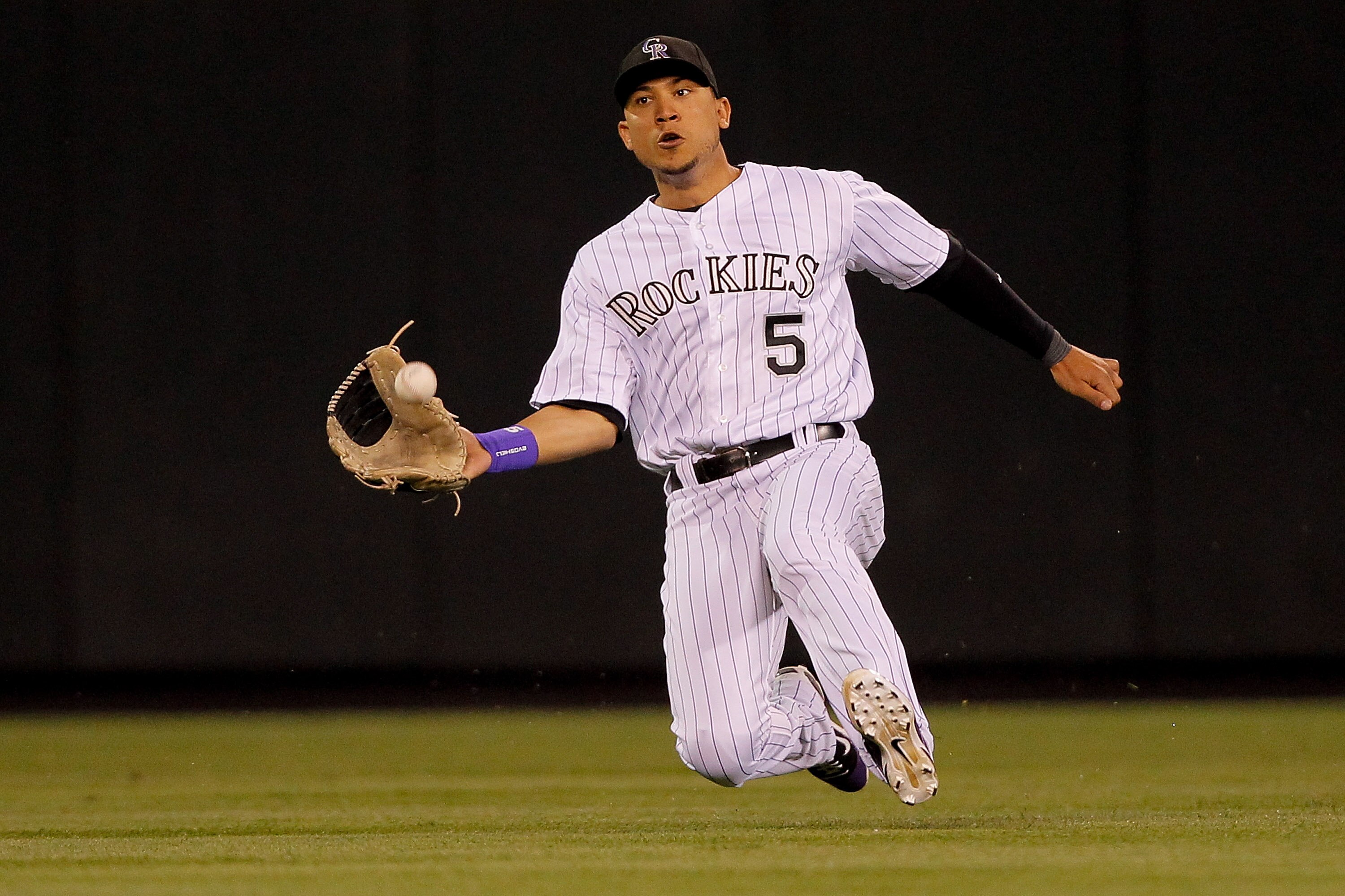 DENVER, CO - JUNE 18:  Center fielder Carlos Gonzalez #5 of the Colorado Rockies makes a sliding catch off the bat of Jhonny Peralta #27 of the Detroit Tigers for the second out of the eighth inning at Coors Field on June 18, 2011 in Denver, Colorado.  (P
