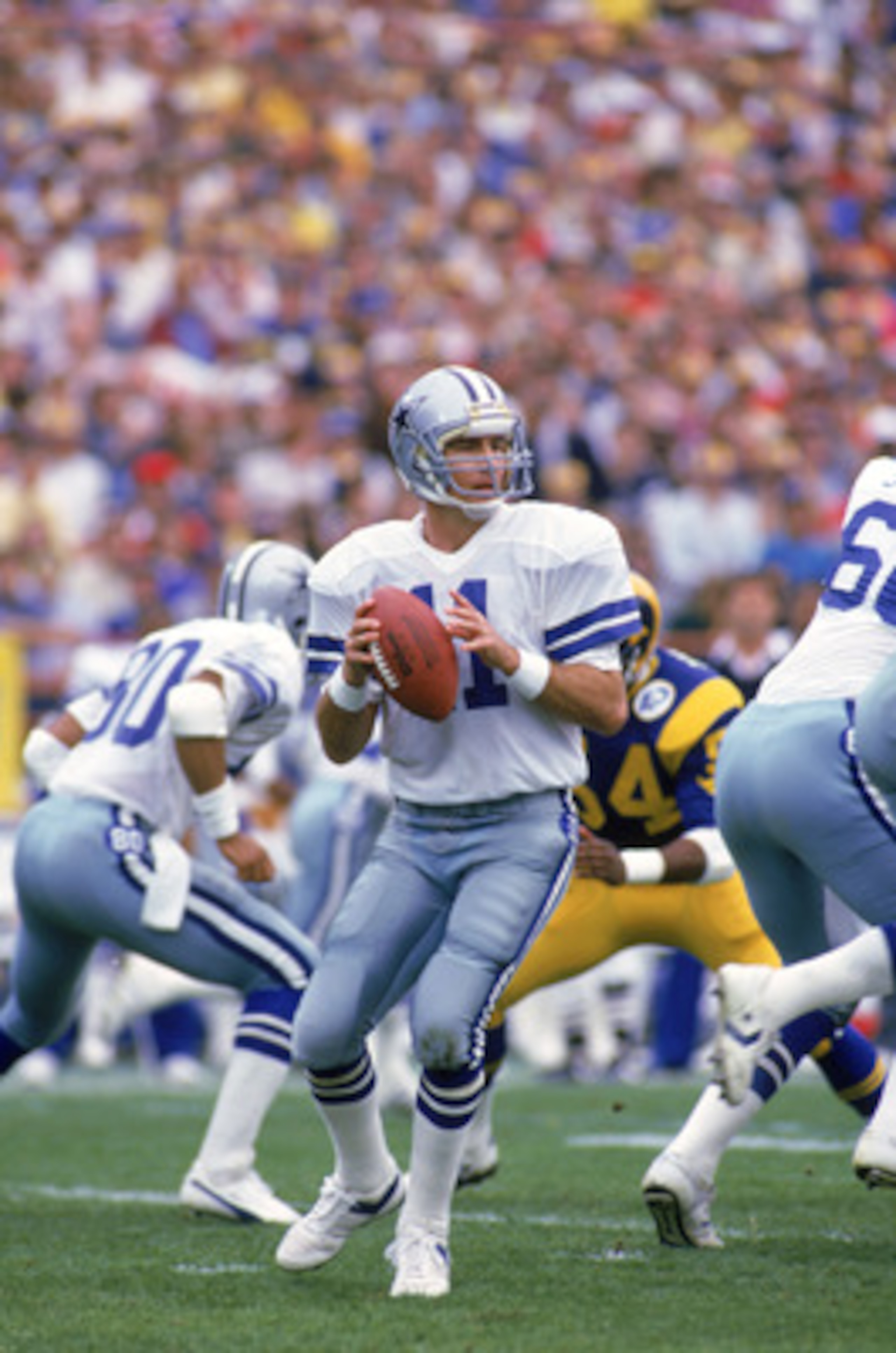 ANAHEIM, CA - JANUARY 4:  Quarterback Danny White #11 of the Dallas Cowboys looks to pass during a 1985 NFC Divisional Playoff game against the Los Angeles Rams at Anaheim Stadium on January 4, 1996 in Anaheim, California.  The Rams won 20-0.  (Photo by G