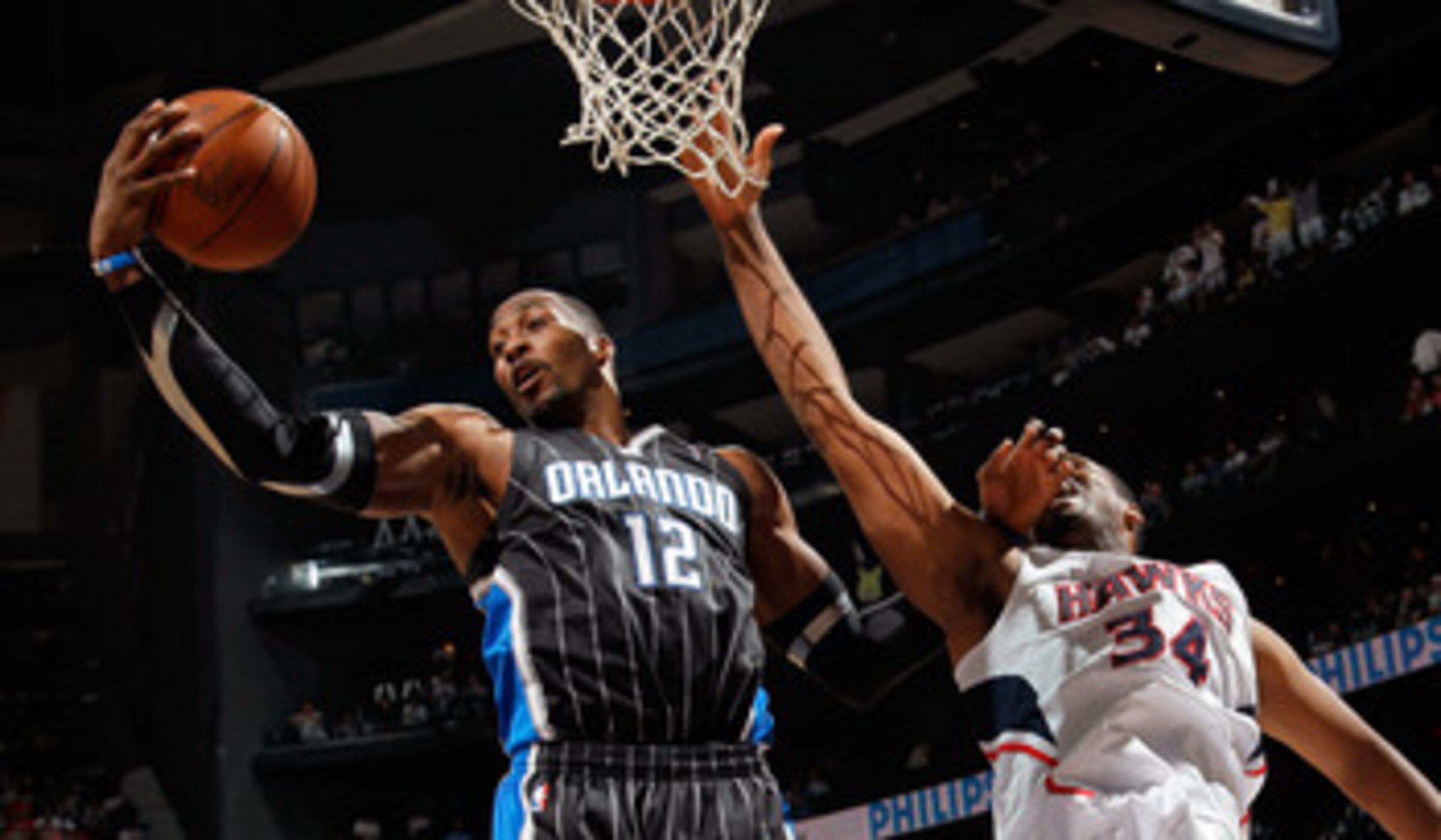 ATLANTA, GA - APRIL 24:  Dwight Howard #12 of the Orlando Magic grabs a rebound against Jason Collins #34 of the Atlanta Hawks during Game Four of the Eastern Conference Quarterfinals in the 2011 NBA Playoffs at Philips Arena on April 24, 2011 in Atlanta,