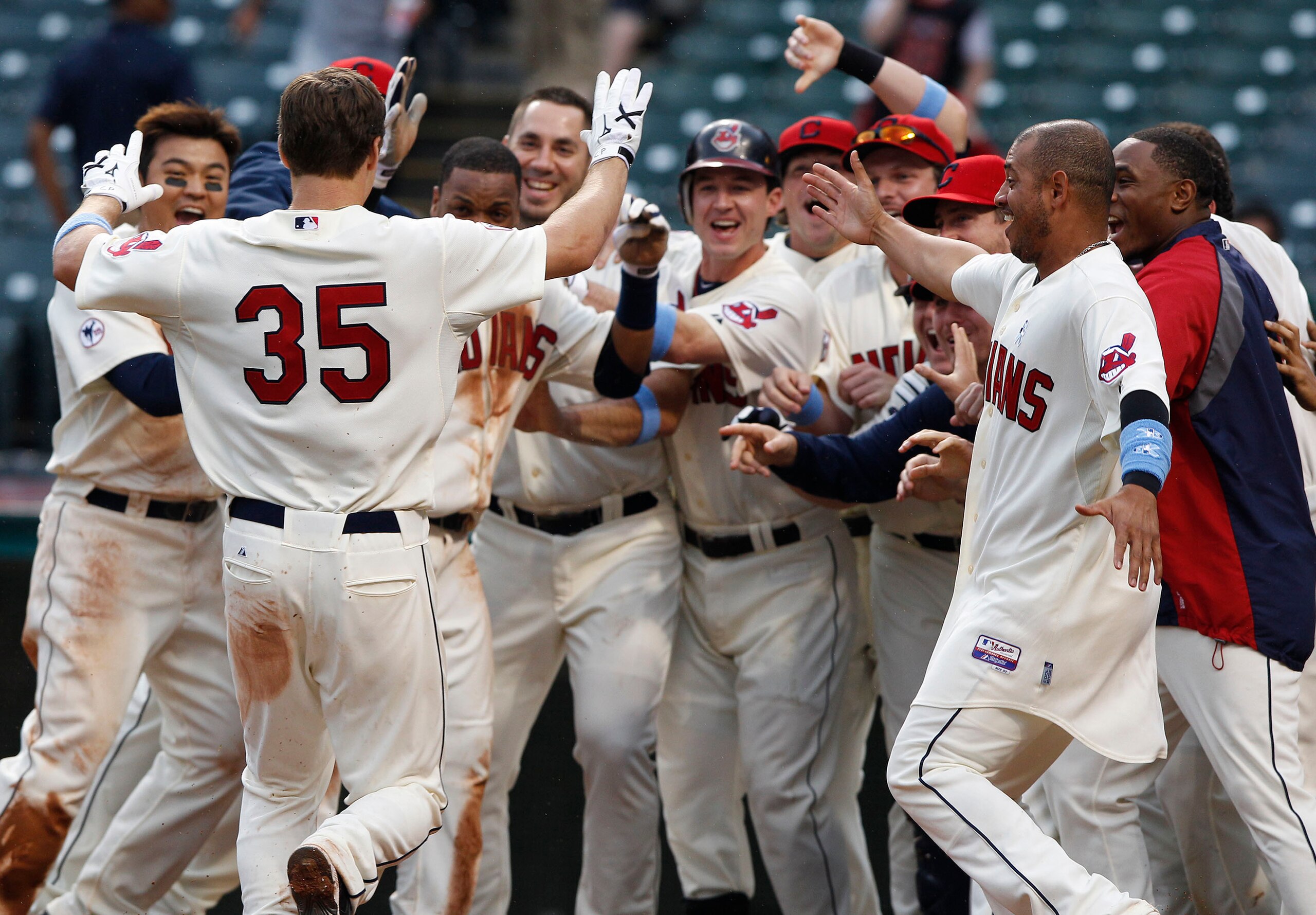 CLEVELAND, OH - JUNE 19:   Cord Phelps #35 of the Cleveland Indians is met by teammates at home plate after hitting the game winning home run against the Pittsburgh Pirates during the elevelnth  inning of their game on June 19, 2011 at Progressive Field i