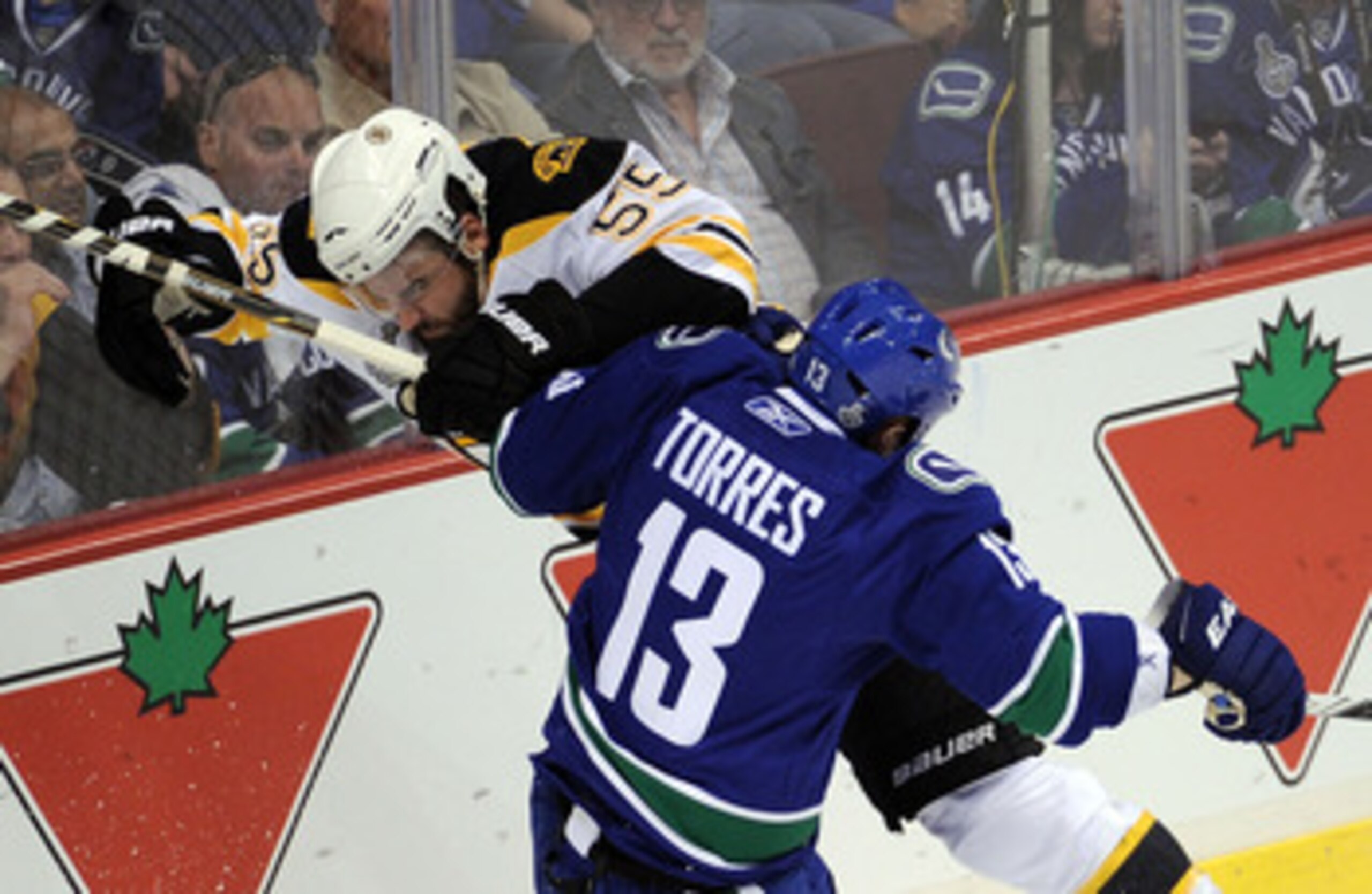 VANCOUVER, BC - JUNE 10:  Johnny Boychuk #55 of the Boston Bruins collides with Raffi Torres #13 of the Vancouver Canucks during Game Five of the 2011 NHL Stanley Cup Final at Rogers Arena on June 10, 2011 in Vancouver, British Columbia, Canada.  (Photo b