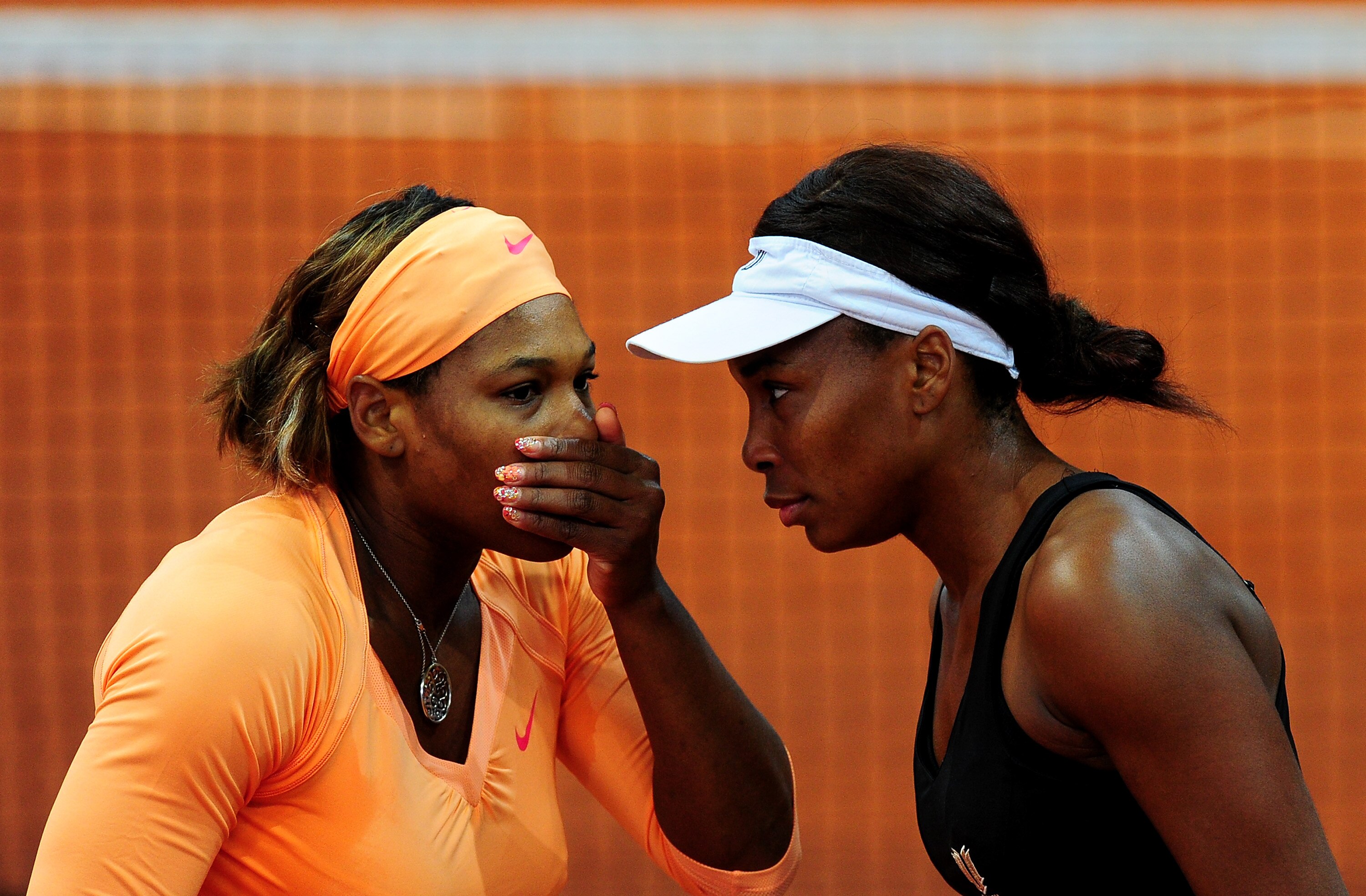 MADRID, SPAIN - MAY 13:  Serena Williams (L) of the USA talks with her sister Venus Williams in their quarter final doubles match against Maria Kirilenko of Russia and Agnieszka Raswanska of Poland during the Mutua Madrilena Madrid Open tennis tournament