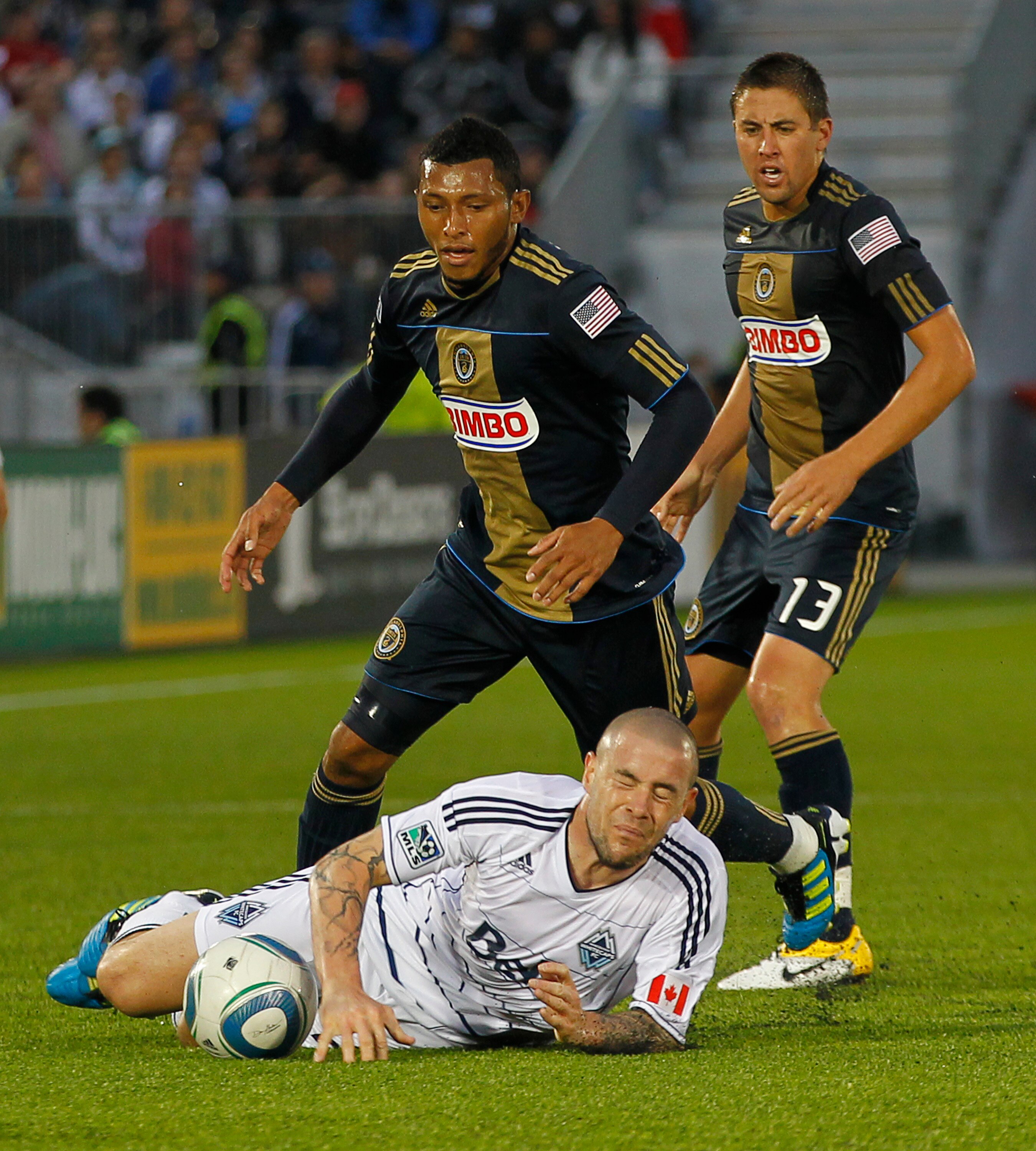 VANCOUVER, CANADA - JUNE 18:  Carlos Valdes #5 and Kyle Nakazawa #13 of the Philadelphia Union look on as Eric Hassli #29 of the Vancouver Whitecaps FC falls to the pitch during their MLS game at Empire Field on June 18, 2011 in Vancouver, British Columbi