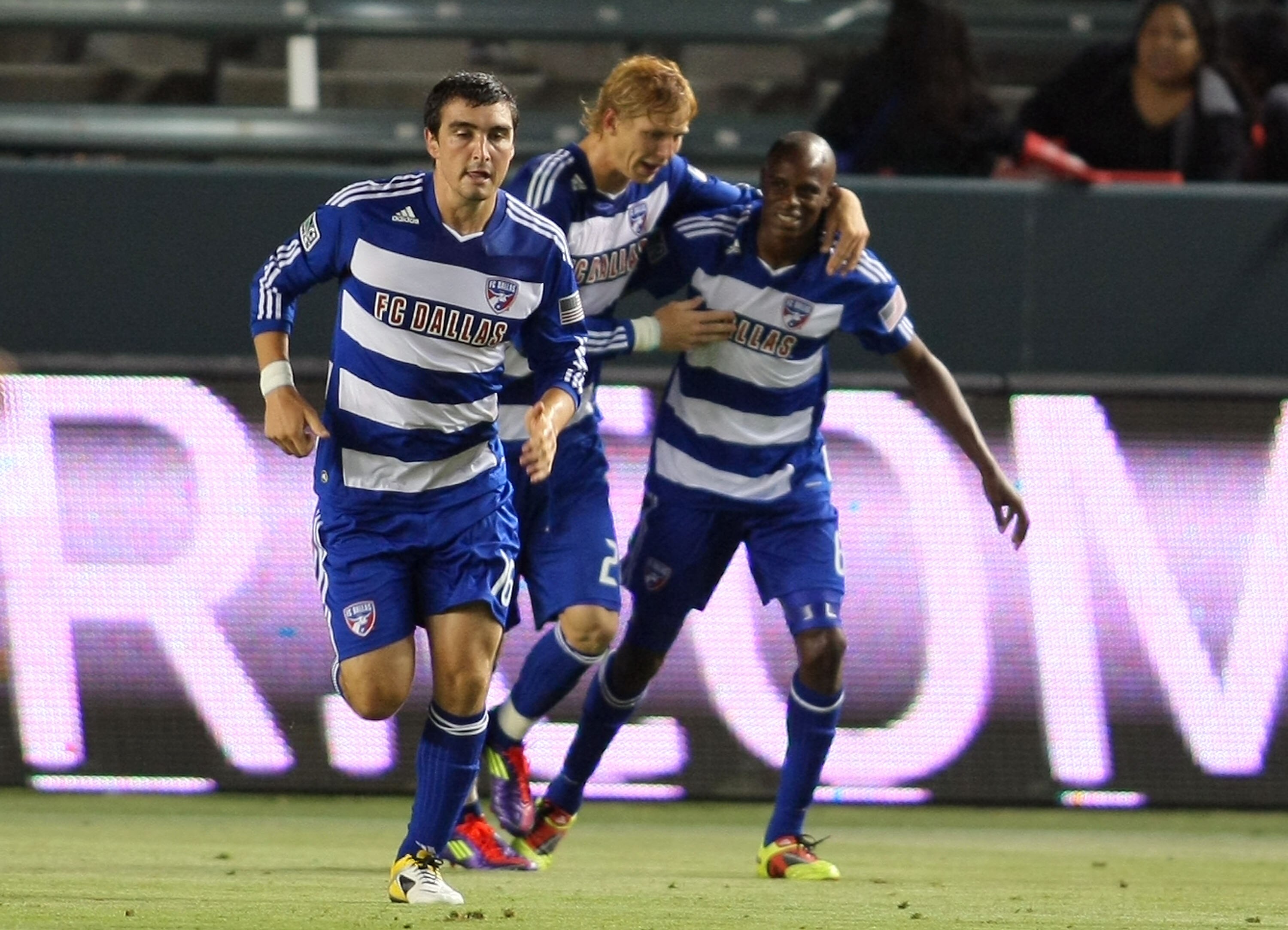 CARSON, CA - JUNE 18:  Brek Shea #20 of FC Dallas congratulates teammate Jackson Goncalves #6 after Goncalves scored to put FC Dallas up 2-1 against Chivas USA in the second half as teammate Bobby Warshaw #16 jogs upfield during their MLS match at The Hom
