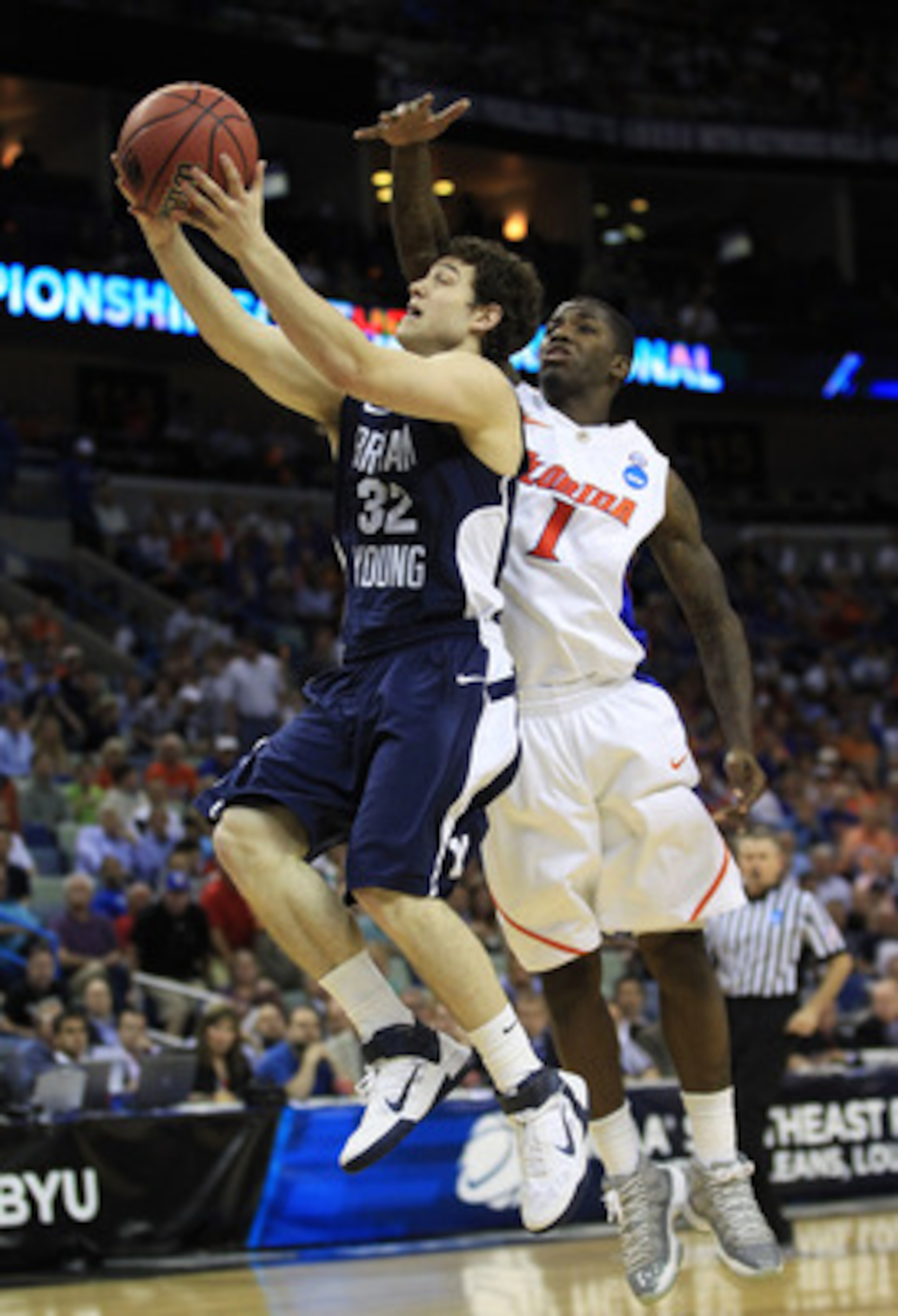 NEW ORLEANS, LA - MARCH 24:  Jimmer Fredette #32 of the Brigham Young Cougars shoots over Kenny Boynton #1 of the Florida Gators in the second half during the Southeast regional of the 2011 NCAA men's basketball tournament at New Orleans Arena on March 24