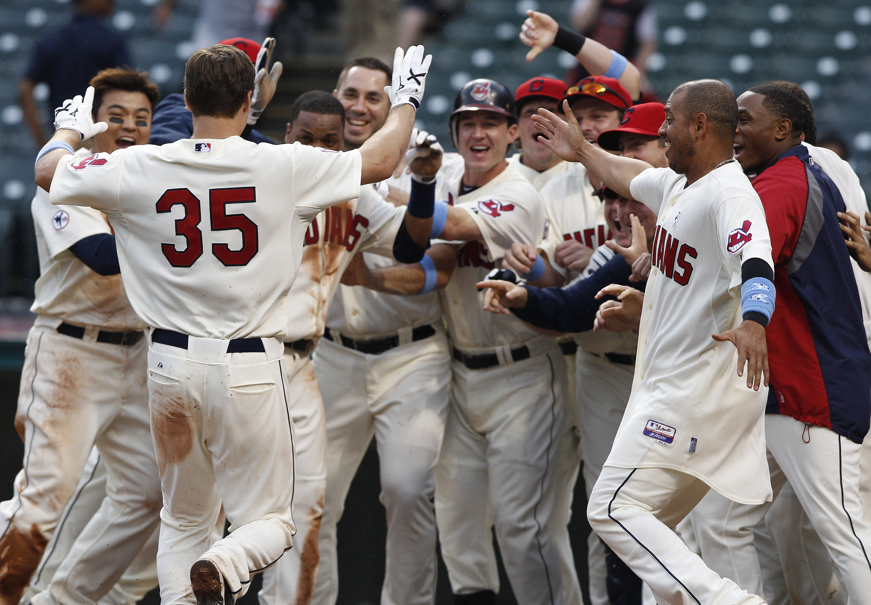 CLEVELAND, OH - JUNE 19:   Cord Phelps #35 of the Cleveland Indians is met by teammates at home plate after hitting the game winning home run against the Pittsburgh Pirates during the elevelnth  inning of their game on June 19, 2011 at Progressive Field i