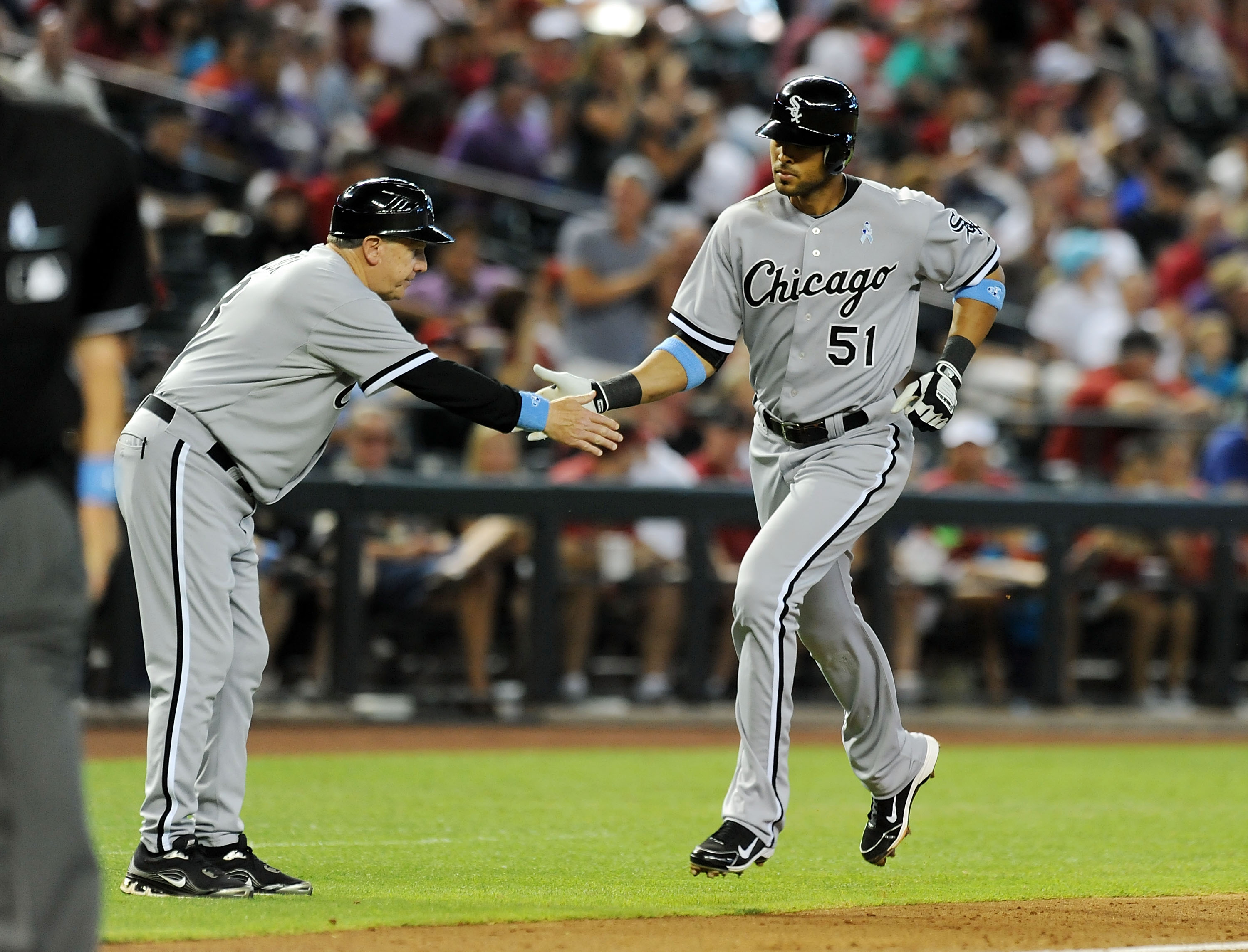 PHOENIX, AZ - JUNE 19:  Alex Rios #51 of the Chicago White Sox gets a high-five from third base coach Jeff Cox #8 after hitting a home run against the Arizona Diamondbacks at Chase Field on June 19, 2011 in Phoenix, Arizona. Chicago won 8-2. (Photo by Nor