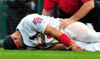 ST. LOUIS, MO - JUNE 19: Albert Pujols #5 of the St. Louis Cardinals holds his wrist after a collision with Wilson Betemit #24 of the Kansas City Royals at Busch Stadium on June 19, 2011 in St. Louis, Missouri.  (Photo by Jeff Curry/Getty Images)