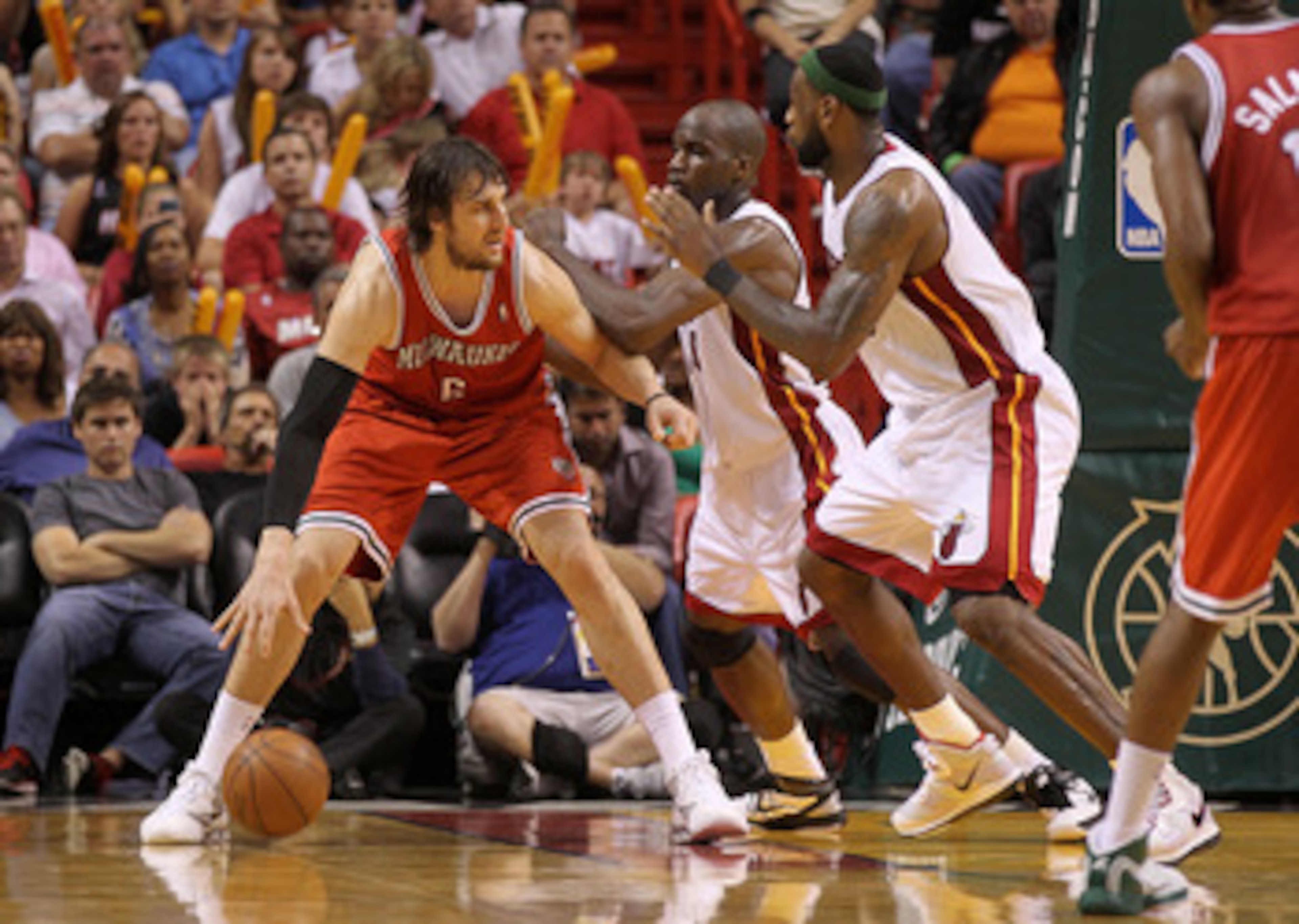 MIAMI, FL - APRIL 06:  Andrew Bogut #6 of the Milwaukee Bucks posts up  Joel Anthony #50 and LeBron James #6 of the Miami Heat during a game at American Airlines Arena on April 6, 2011 in Miami, Florida. NOTE TO USER: User expressly acknowledges and agree