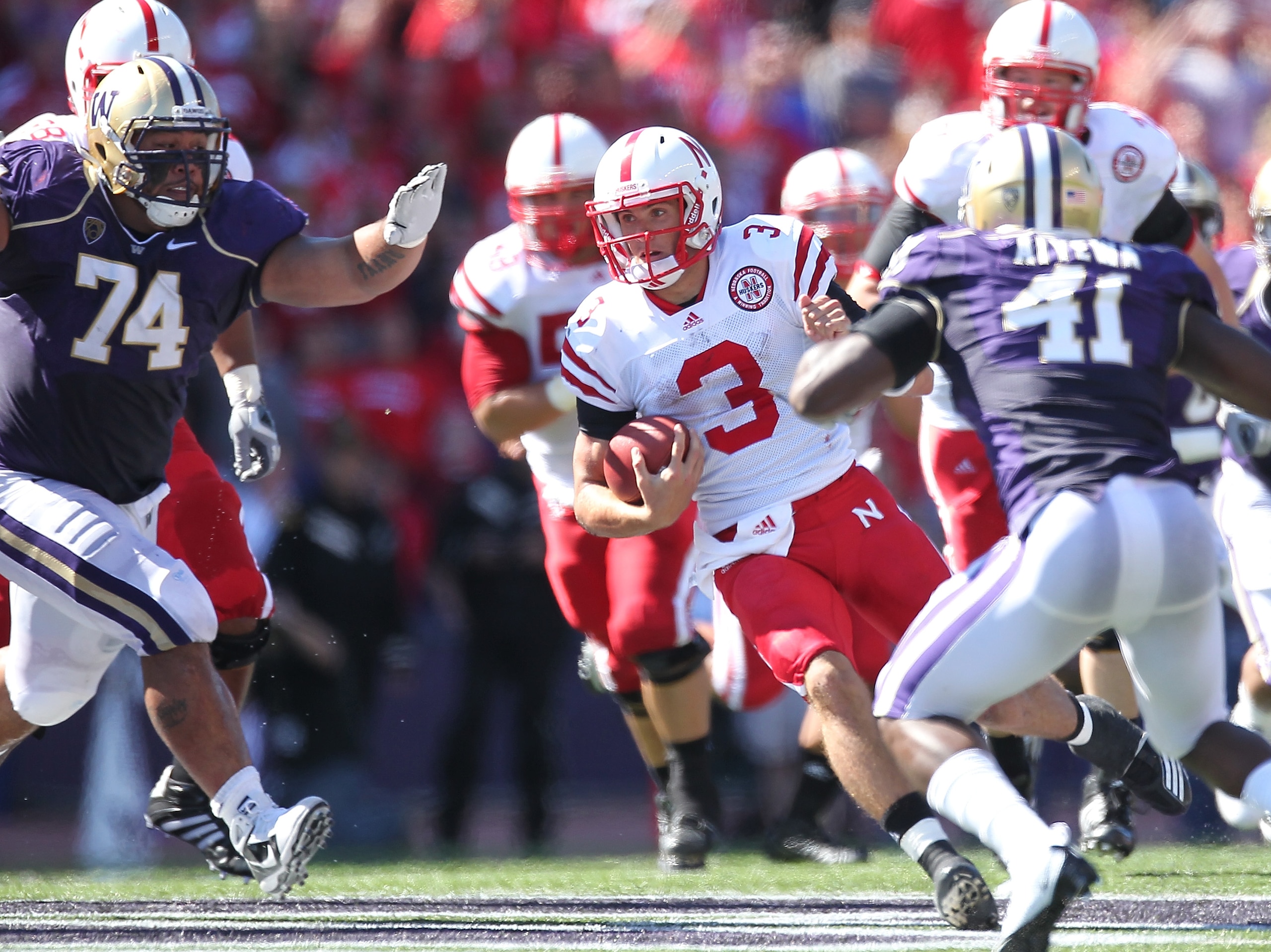 SEATTLE - SEPTEMBER 18:  Quarterback Taylor Martinez #3 of the Nebraska Cornhuskers rushes against Alameda Ta'amu #74 and Victor Aiyewa #41 of the Washington Huskies on September 18, 2010 at Husky Stadium in Seattle, Washington. The Cornhuskers defeated t
