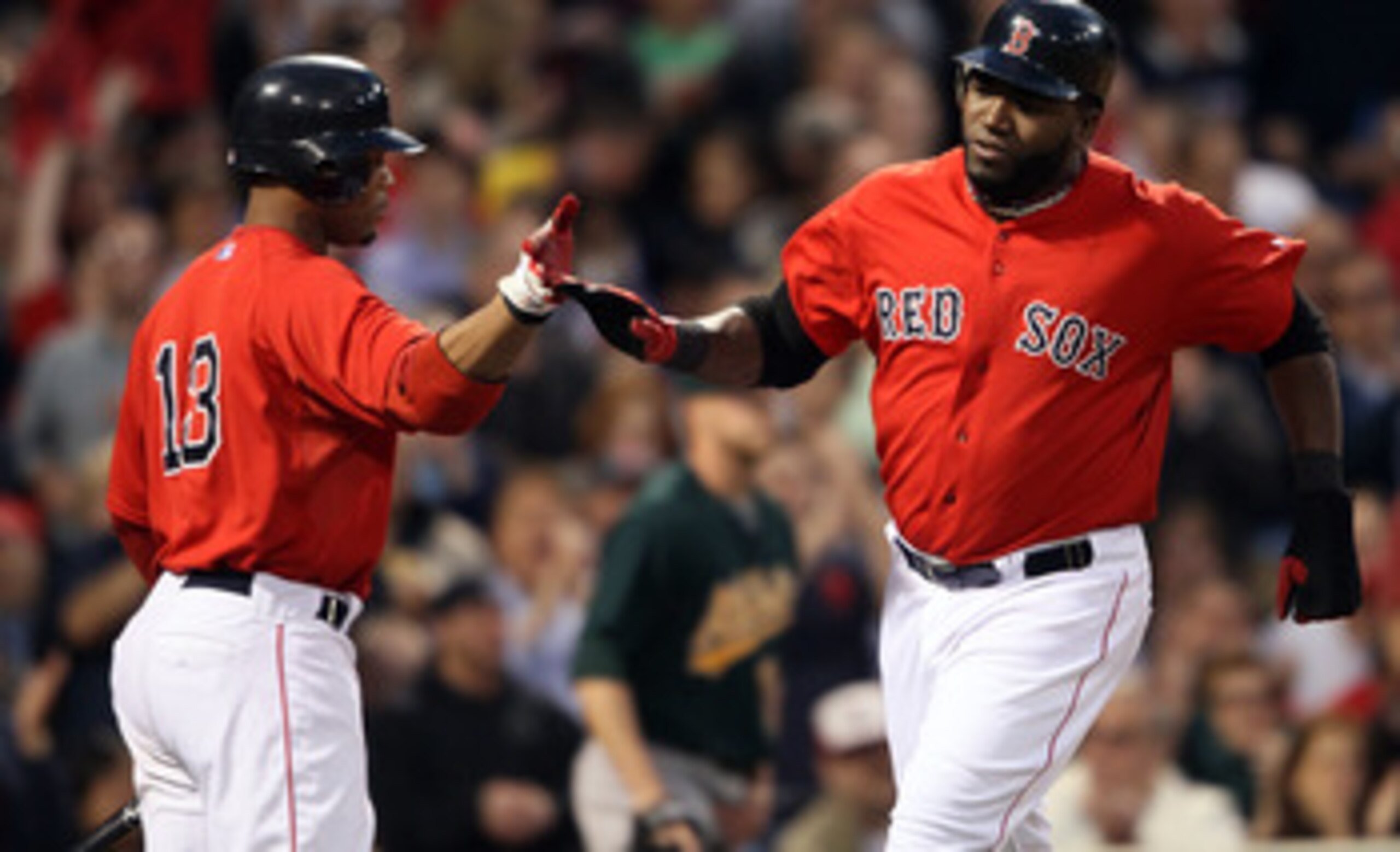BOSTON, MA - JUNE 03:  David Ortiz #34 of the Boston Red Sox celebrates his run with teammate Carl Crawford #13 after Ortiz scored in the third inning against the Oakland Athletics on June 3, 2011 at Fenway Park in Boston, Massachusetts.  (Photo by Elsa/G