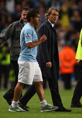 MANCHESTER, ENGLAND - MAY 17:  Carlos Tevez of Manchester City walks on to the pitch for a lap of honour with his manager Roberto Mancini after the Barclays Premier League match between Manchester City and Stoke City at City of Manchester Stadium on May 1