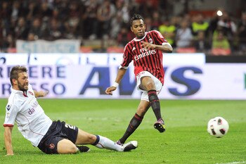 MILAN, ITALY - MAY 14:  Robinho (R) of Milan shoots at goal as he is challenged by Gabriele Perico of Cagliari during the Serie A match between AC Milan and Cagliari Calcio at Stadio Giuseppe Meazza on May 14, 2011 in Milan, Italy.  (Photo by Dino Panato/