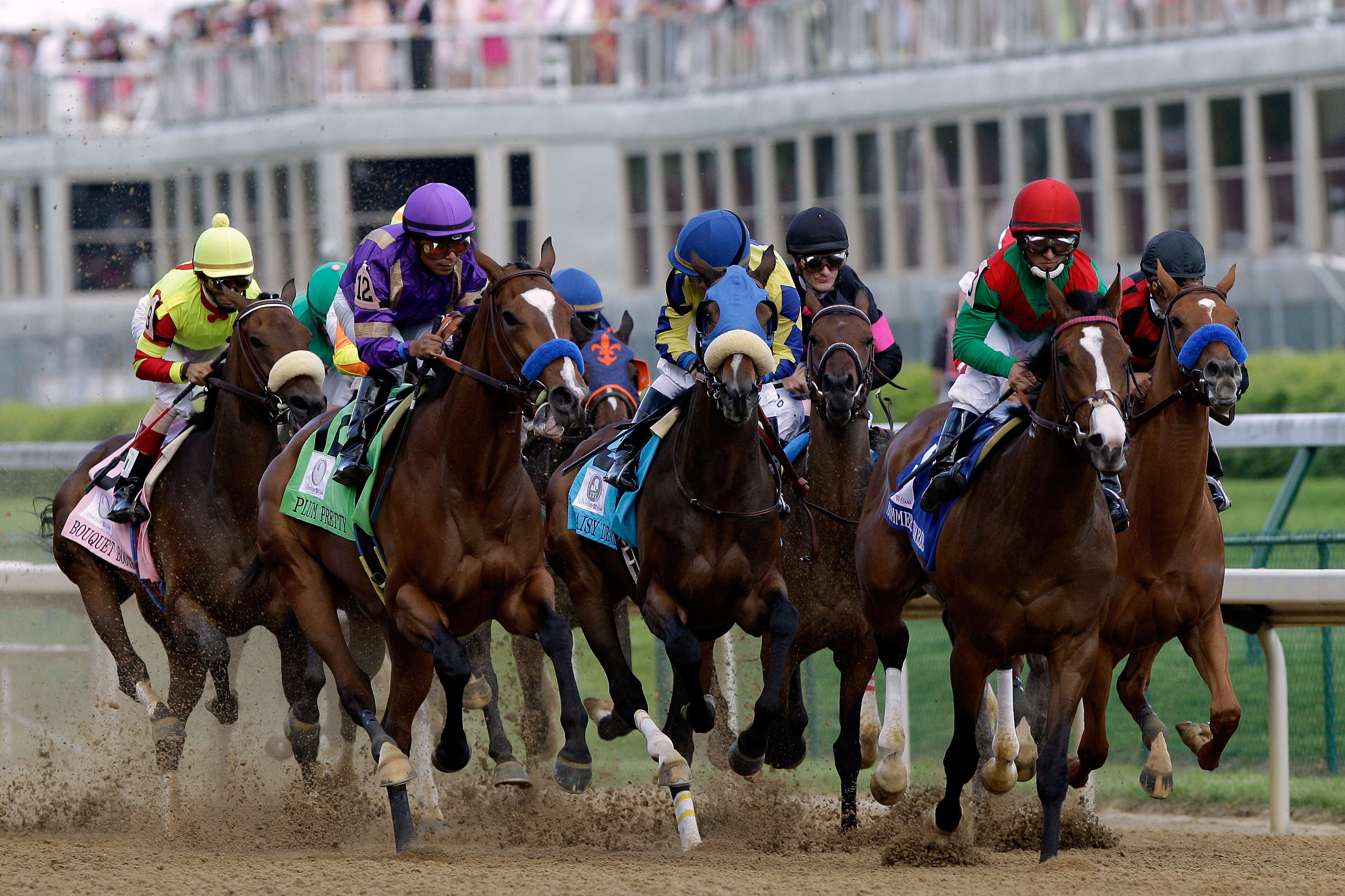LOUISVILLE, KY - MAY 06:  Jockey Martin Garcia (2nd L), riding Plum Pretty #12 and Jockey Gabriel Saez (2nd R), riding Summer Soiree #3, lead the field down the front stretch at the start of the 137th Kentucky Oaks at Churchill Downs on May 6, 2011 in Lou