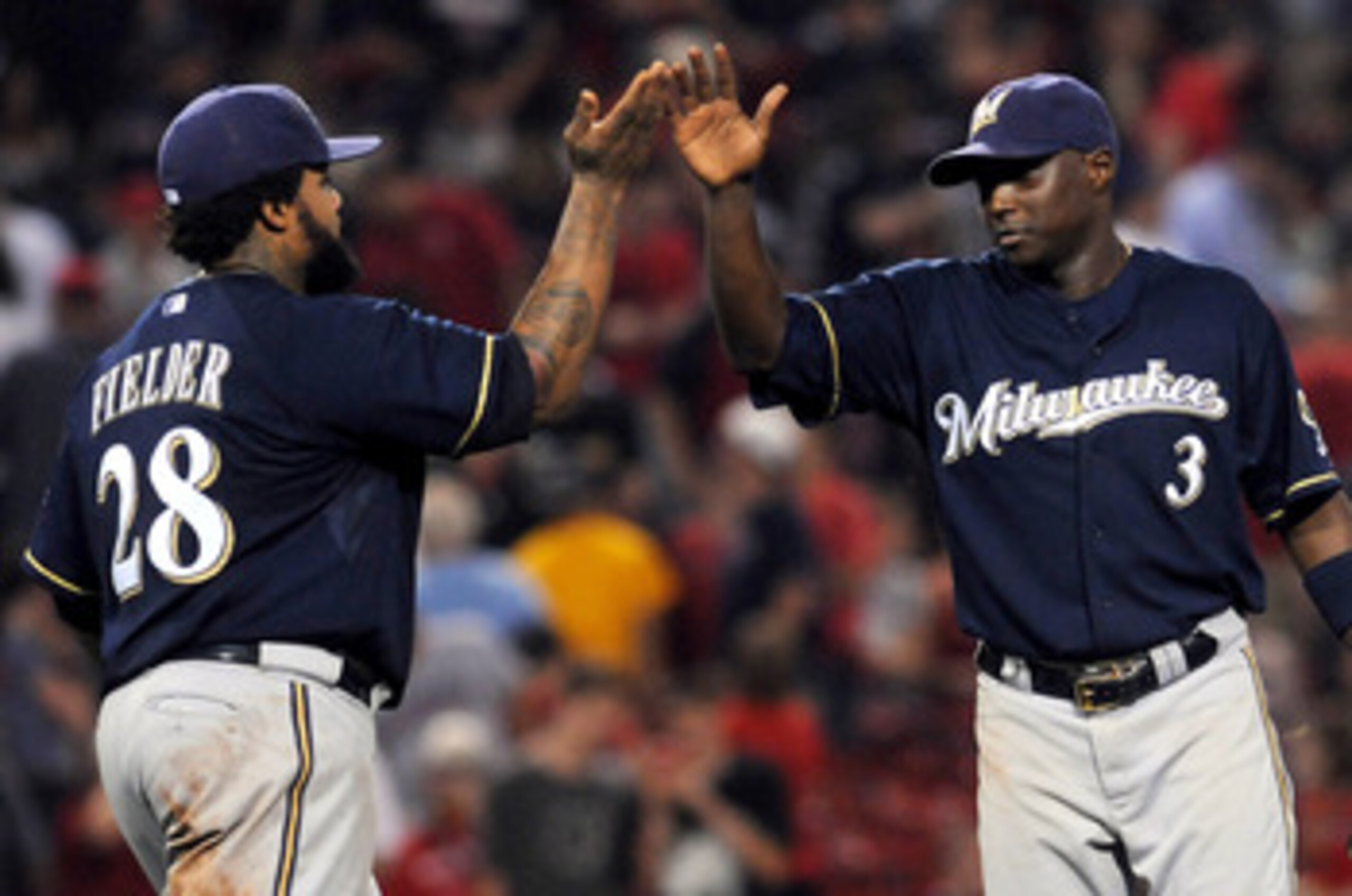 BOSTON, MA - JUNE 18:  Prince Fielder #28 and Yuniesky Betancourt #3 of the Milwaukee Brewers high five after their win against the Boston Red Sox at Fenway Park on June 18, 2011 in Boston, Massachusetts. The Brewers won the game 4-2. (Photo by Darren McC