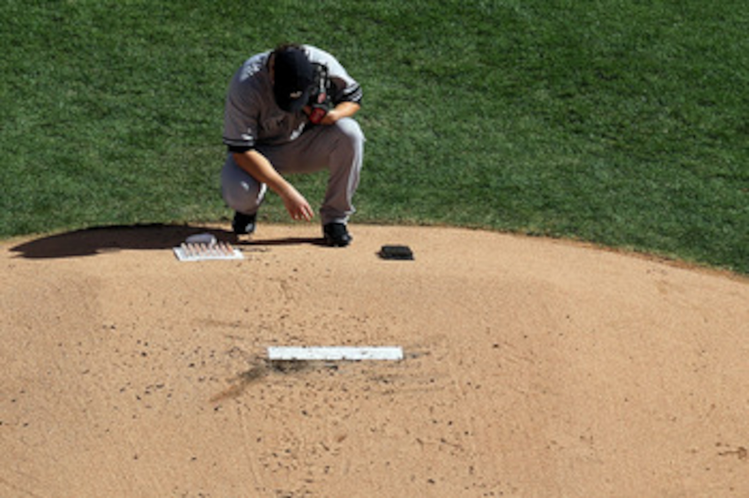 ARLINGTON, TX - OCTOBER 16:  Phil Hughes #65 of the New York Yankees crouches behind the pitchers mound prior to the start of the bottom of the first inning against the Texas Rangers in Game Two of the ALCS during the 2010 MLB Playoffs at Rangers Ballpark