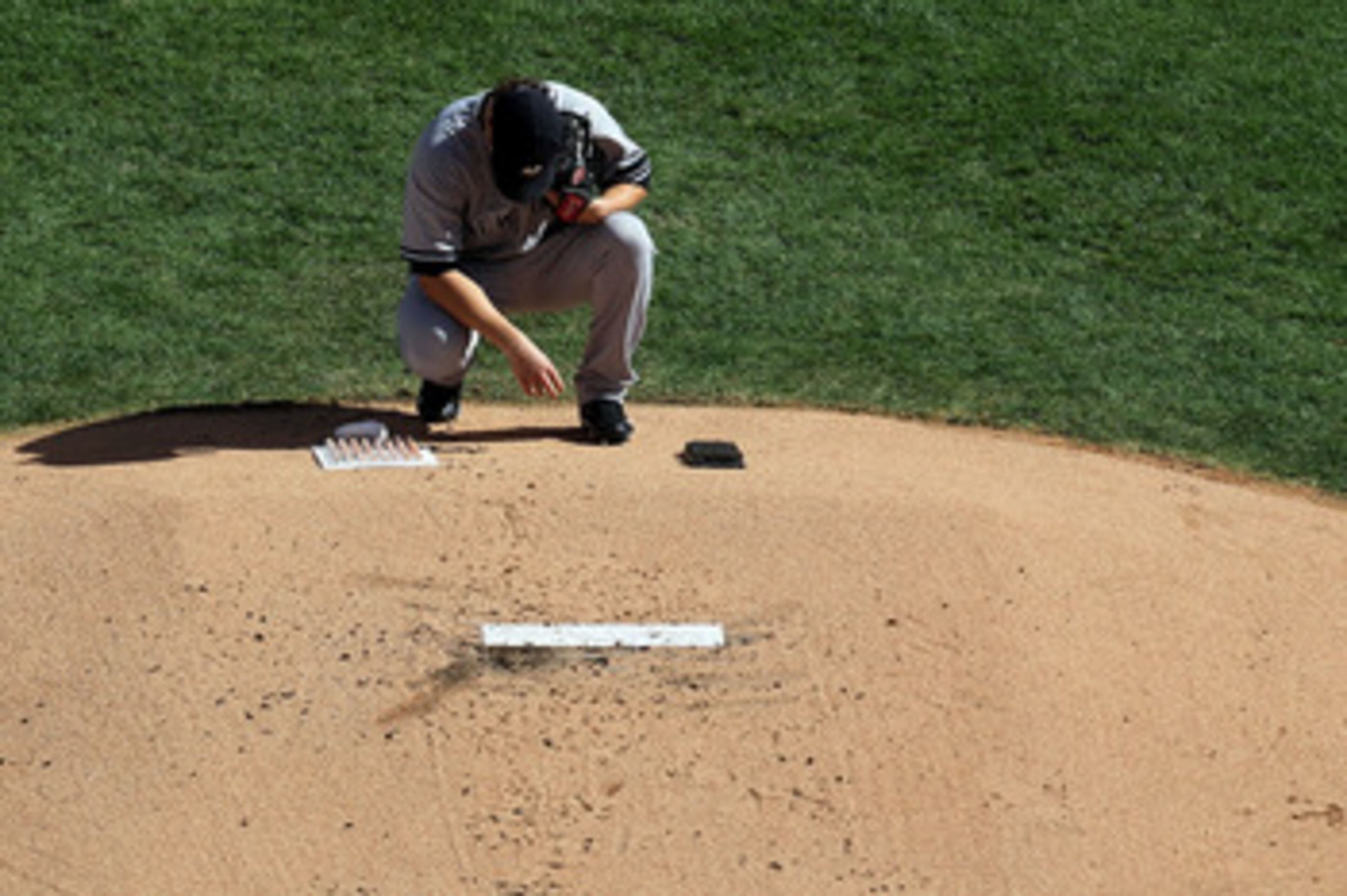 ARLINGTON, TX - OCTOBER 16:  Phil Hughes #65 of the New York Yankees crouches behind the pitchers mound prior to the start of the bottom of the first inning against the Texas Rangers in Game Two of the ALCS during the 2010 MLB Playoffs at Rangers Ballpark