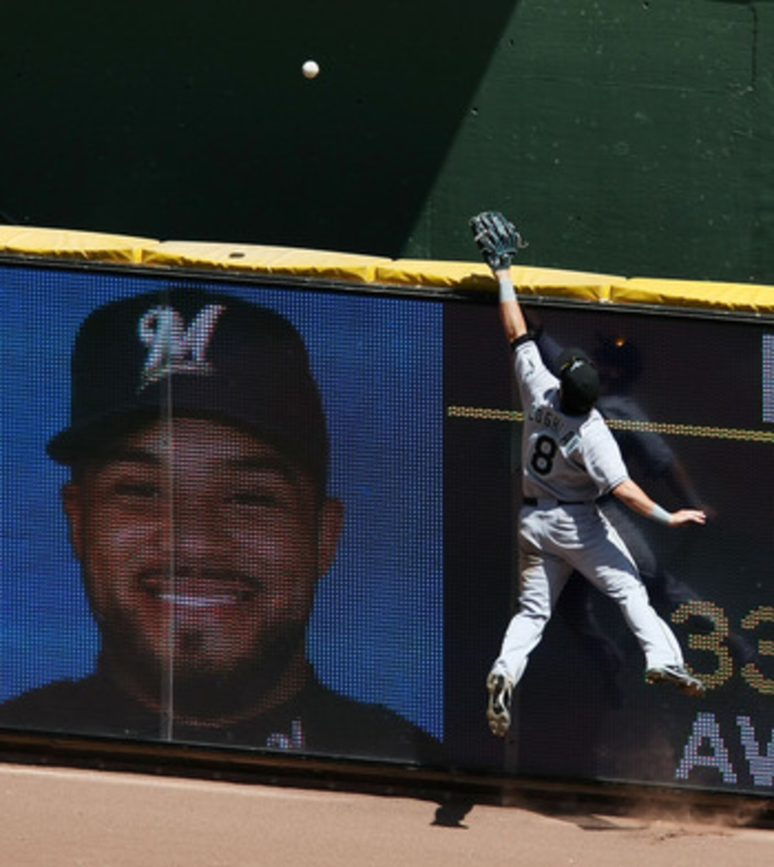 MILWAUKEE - MAY 14: Chris Coghlan #8 of the Florida Marlins leaps in vain to try and catch a home run ball hit by Prince Fielder of the Milwaukee Brewers, whose photo appears on the outfield view screen, on May 14, 2009 at Miller Park in Milwaukee, Wiscon
