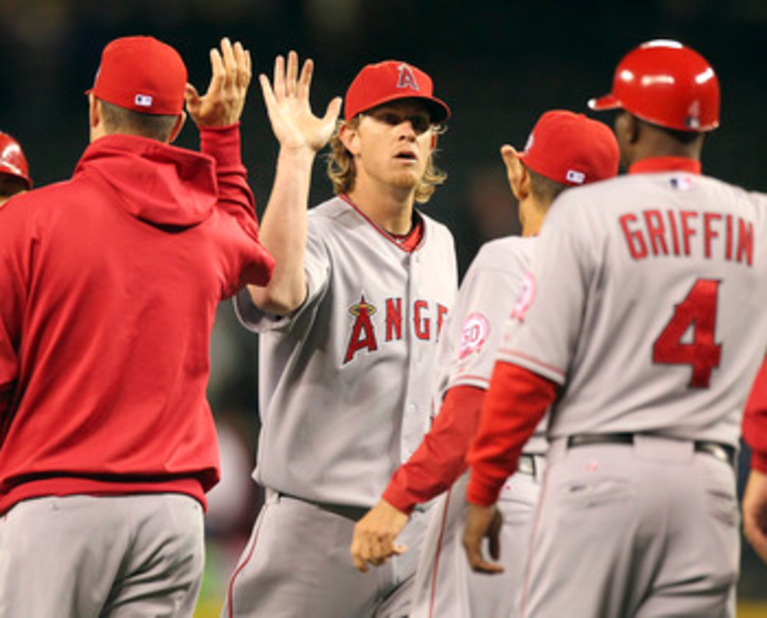 SEATTLE - JUNE 14:  Starting pitcher Jered Weaver #36 of the Los Angeles Angels of Anaheim celebrates with teammates after throwing a complete game 4-0 shutout against the Seattle Mariners at Safeco Field on June 14, 2011 in Seattle, Washington. (Photo by